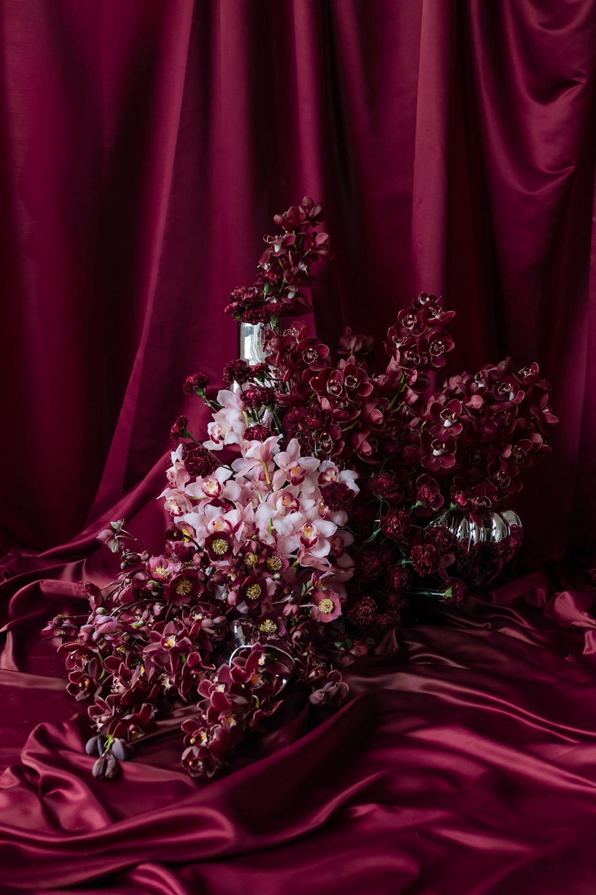 Pink and burgundy orchid arrangement on magenta satin at Domaine des Halles ceremony