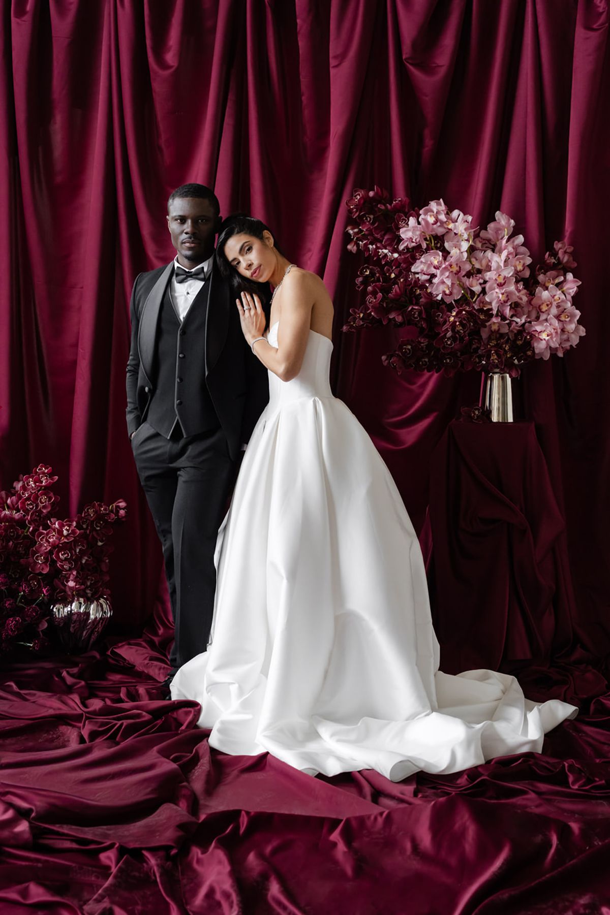 Couple portrait against magenta satin ceremony backdrop at Domaine des Halles