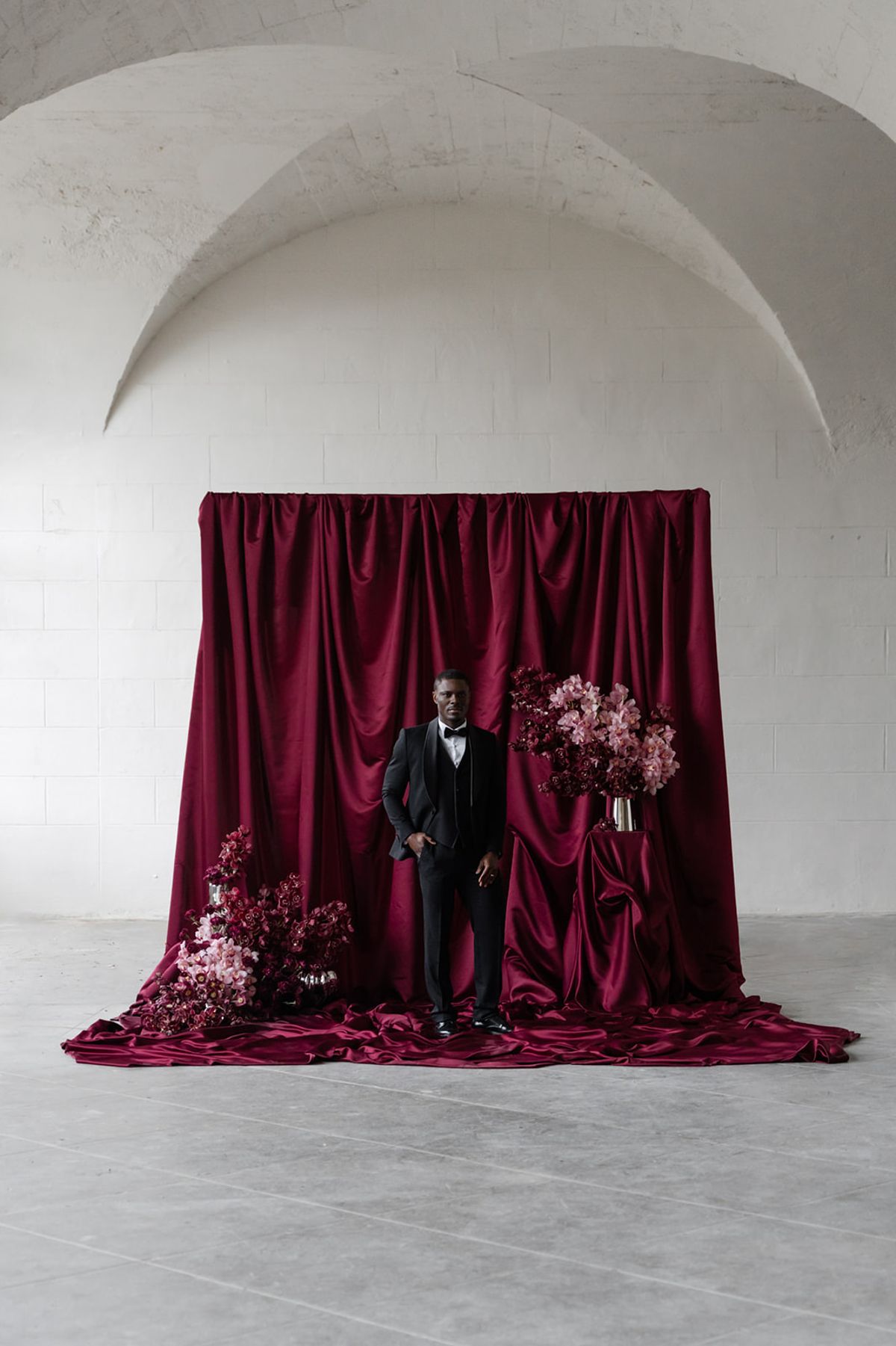 Groom standing at magenta ceremony backdrop at Domaine des Halles
