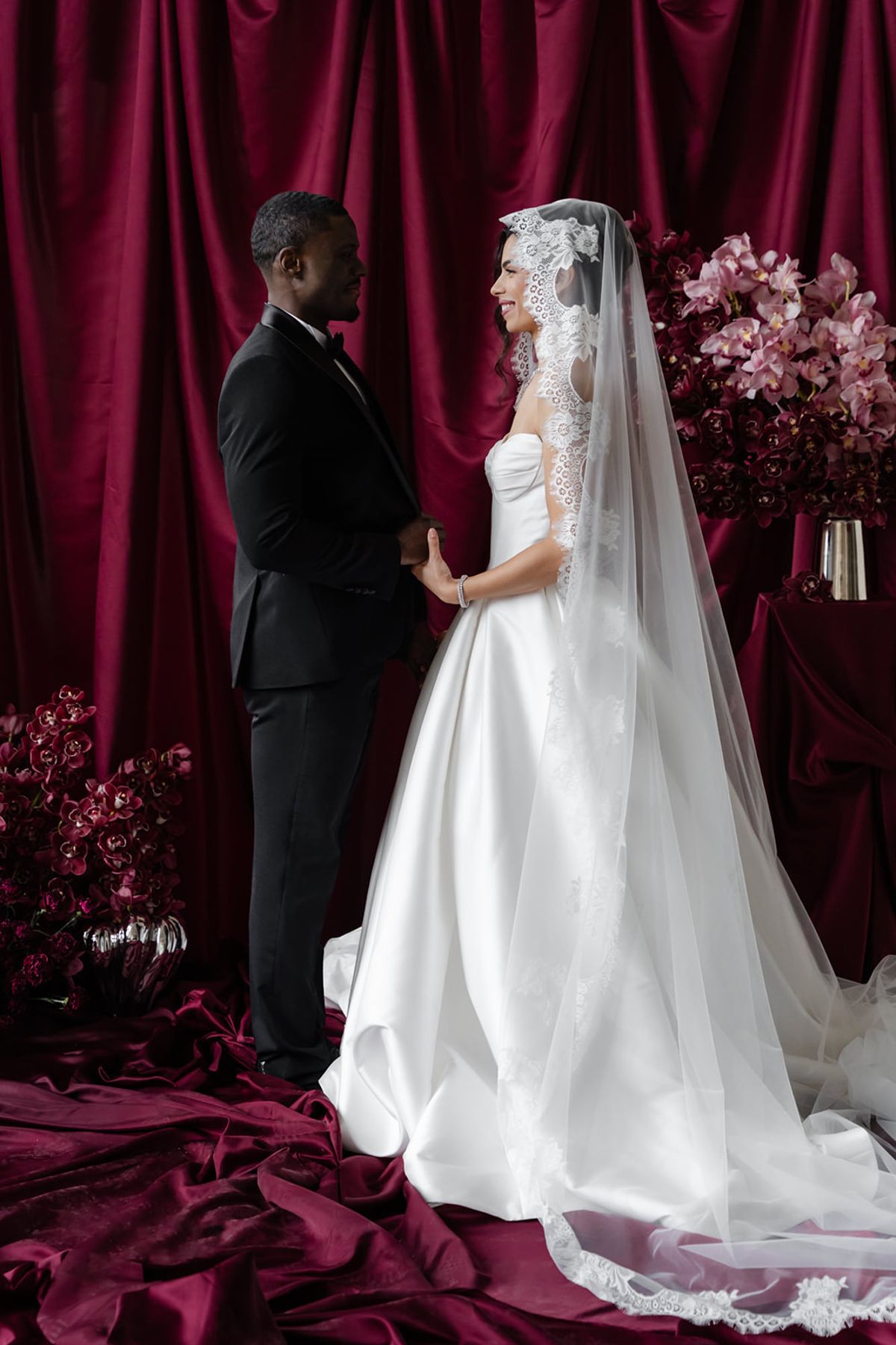 Couple holding hands at ceremony backdrop at Domaine des Halles