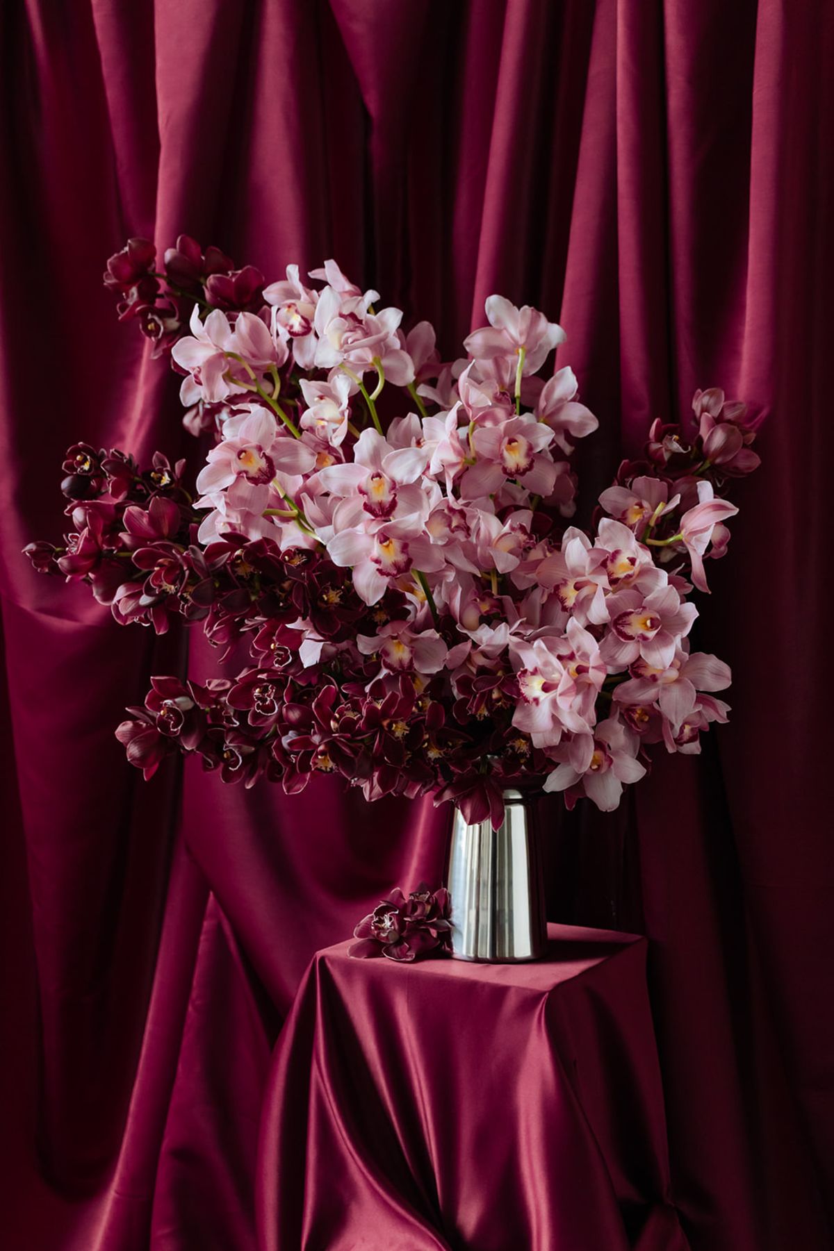 Pink and burgundy orchid arrangement in silver vase at Domaine des Halles ceremony
