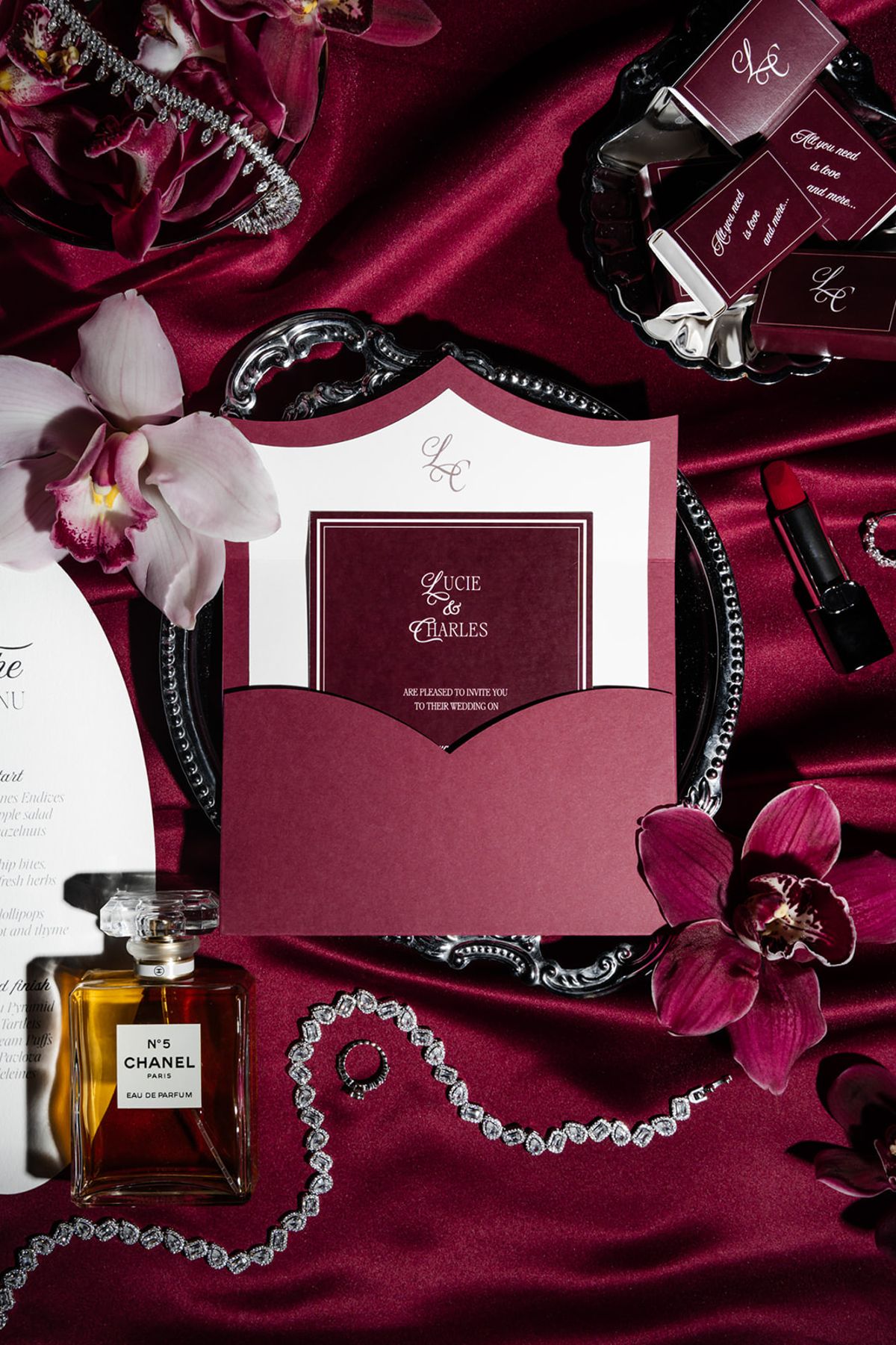 Wedding flatlay with invitation Chanel perfume and diamonds at Domaine des Halles