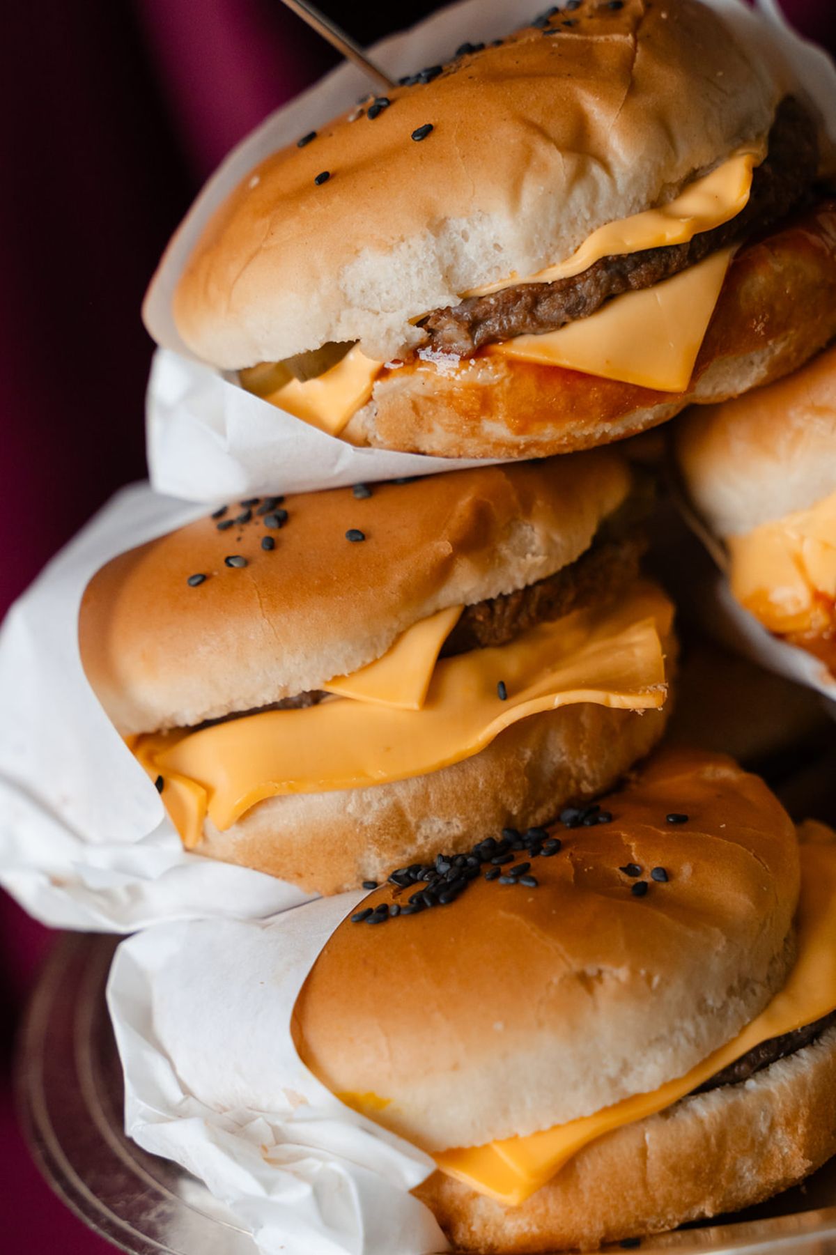 Stacked cheeseburgers on silver stand at Domaine des Halles wedding after-party