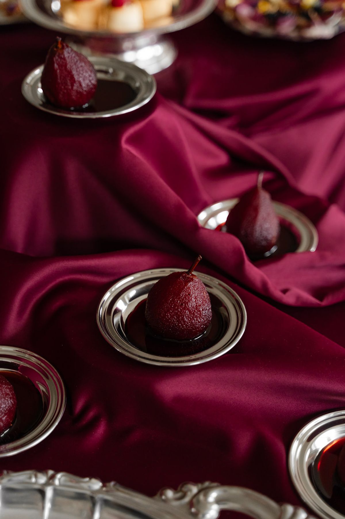 Poached red wine pears on silver plates at Domaine des Halles wedding