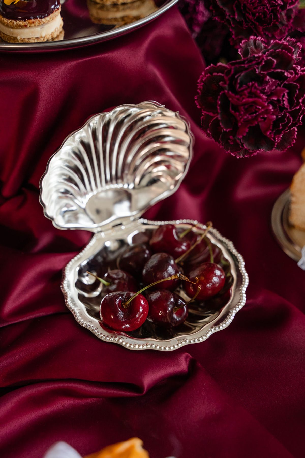 Fresh cherries in silver shell dish at Domaine des Halles wedding dessert table