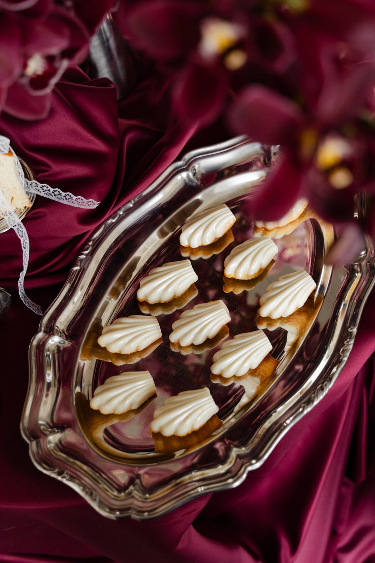 Cream madeleines on silver tray with orchids at Domaine des Halles wedding