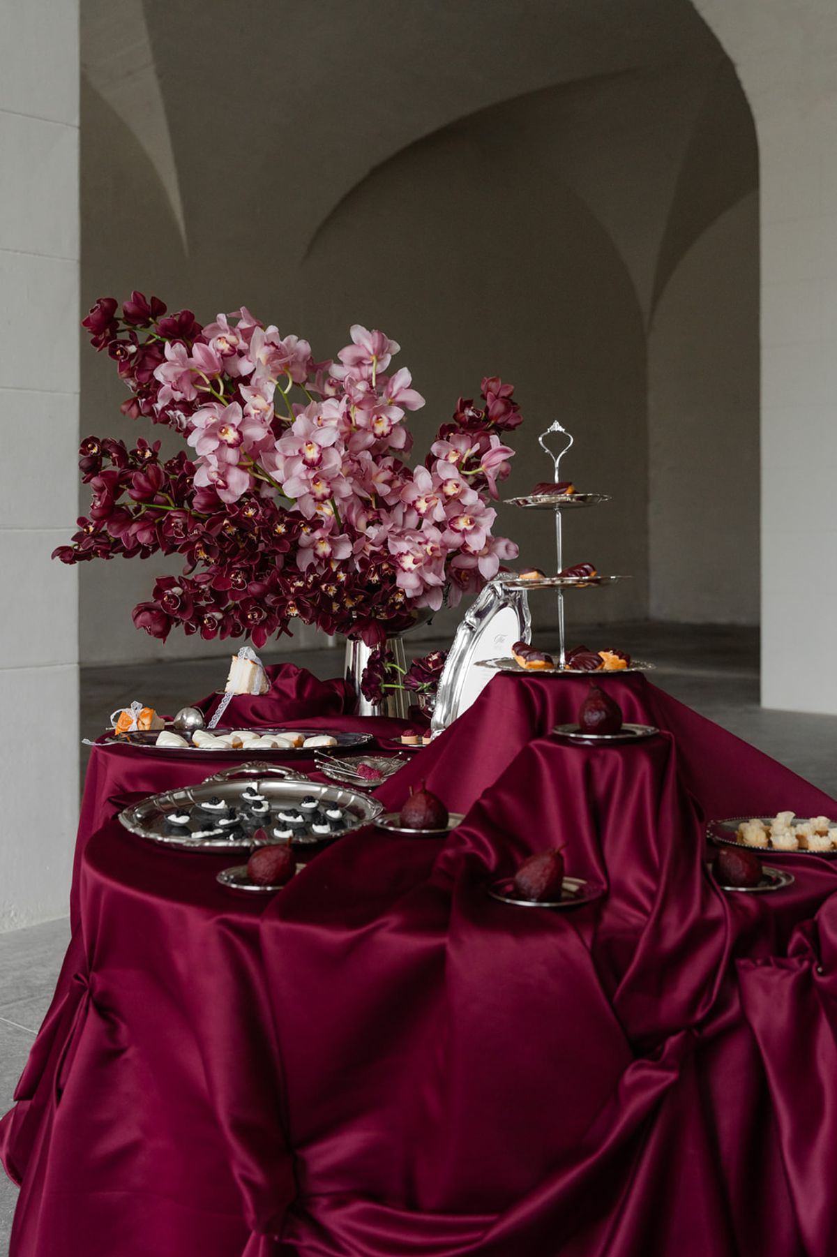 Reception buffet table with red linen and florals at Domaine des Halles