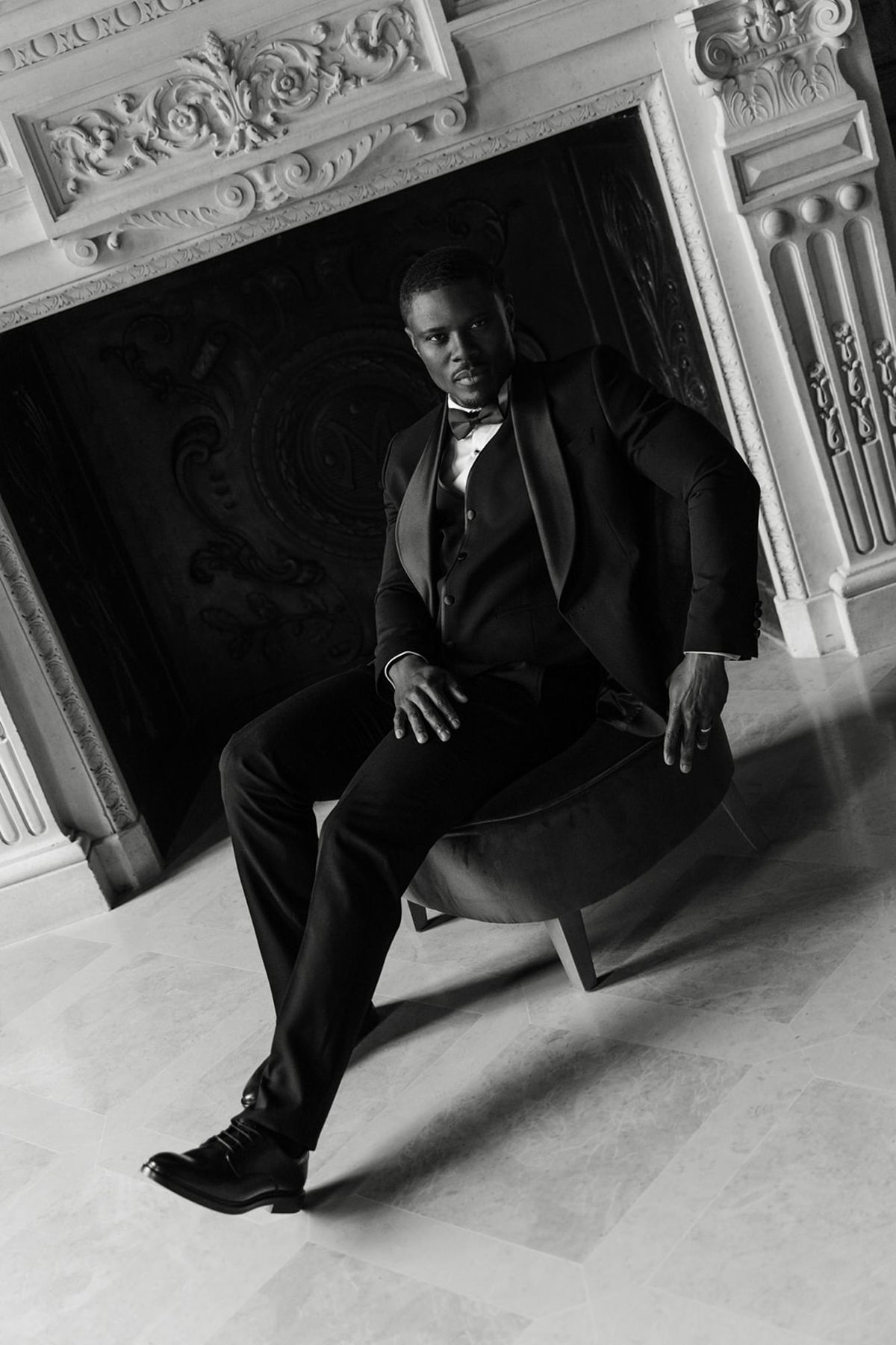 Groom seated in a vintage chateau room at Domaine des Halles