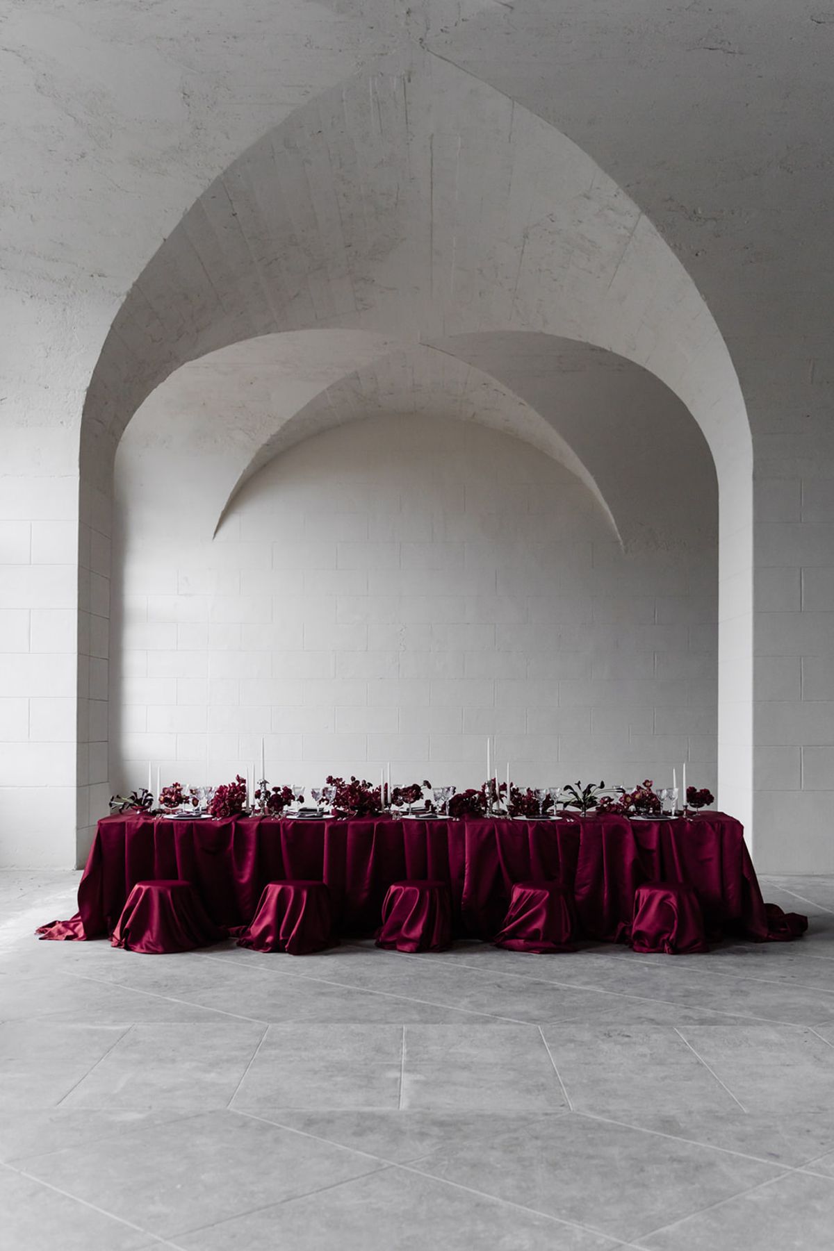 Long reception table dressed in red maroon linen at Domaine des Halles