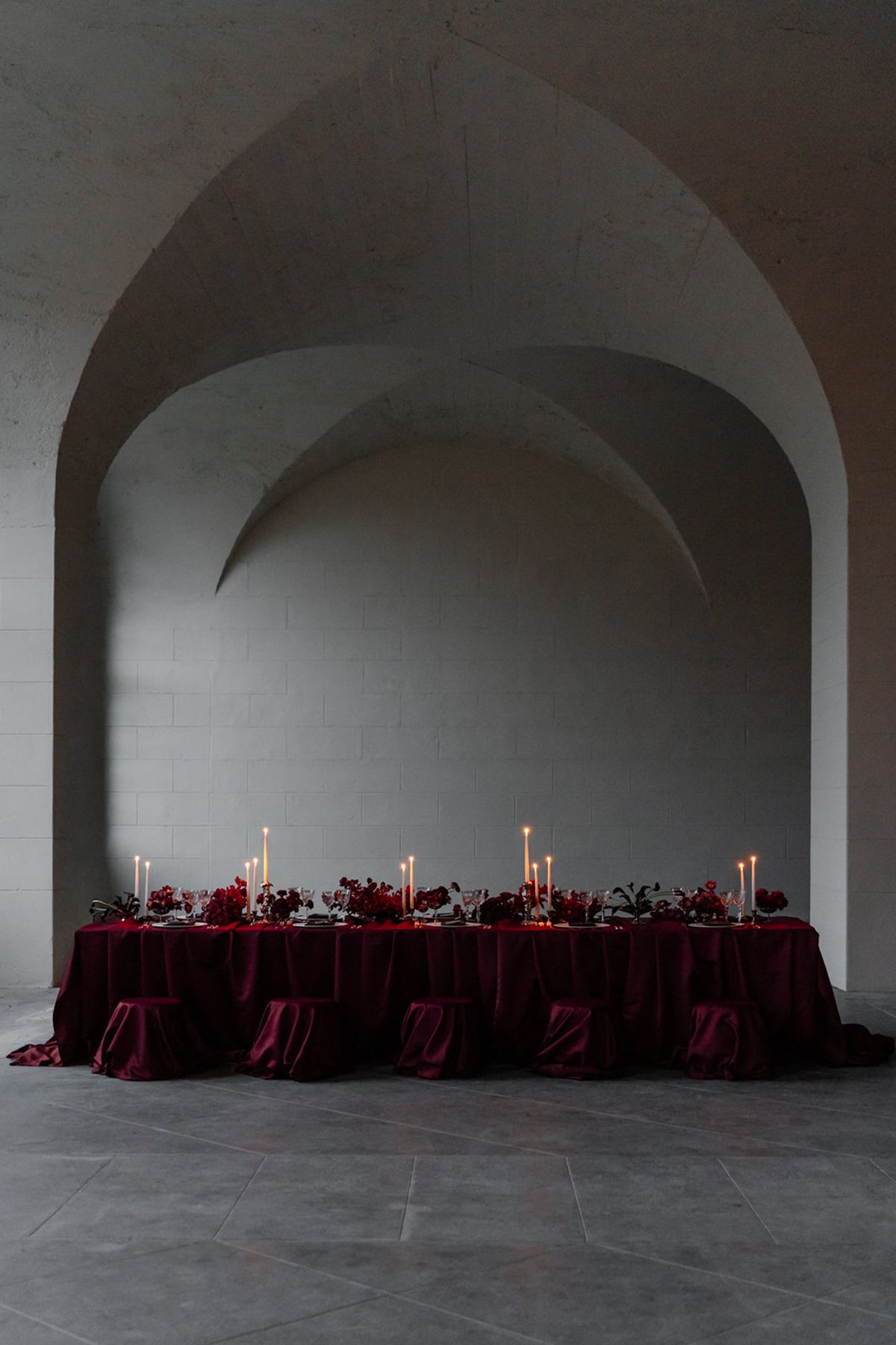 Long candlelit reception table in deep red at Domaine des Halles