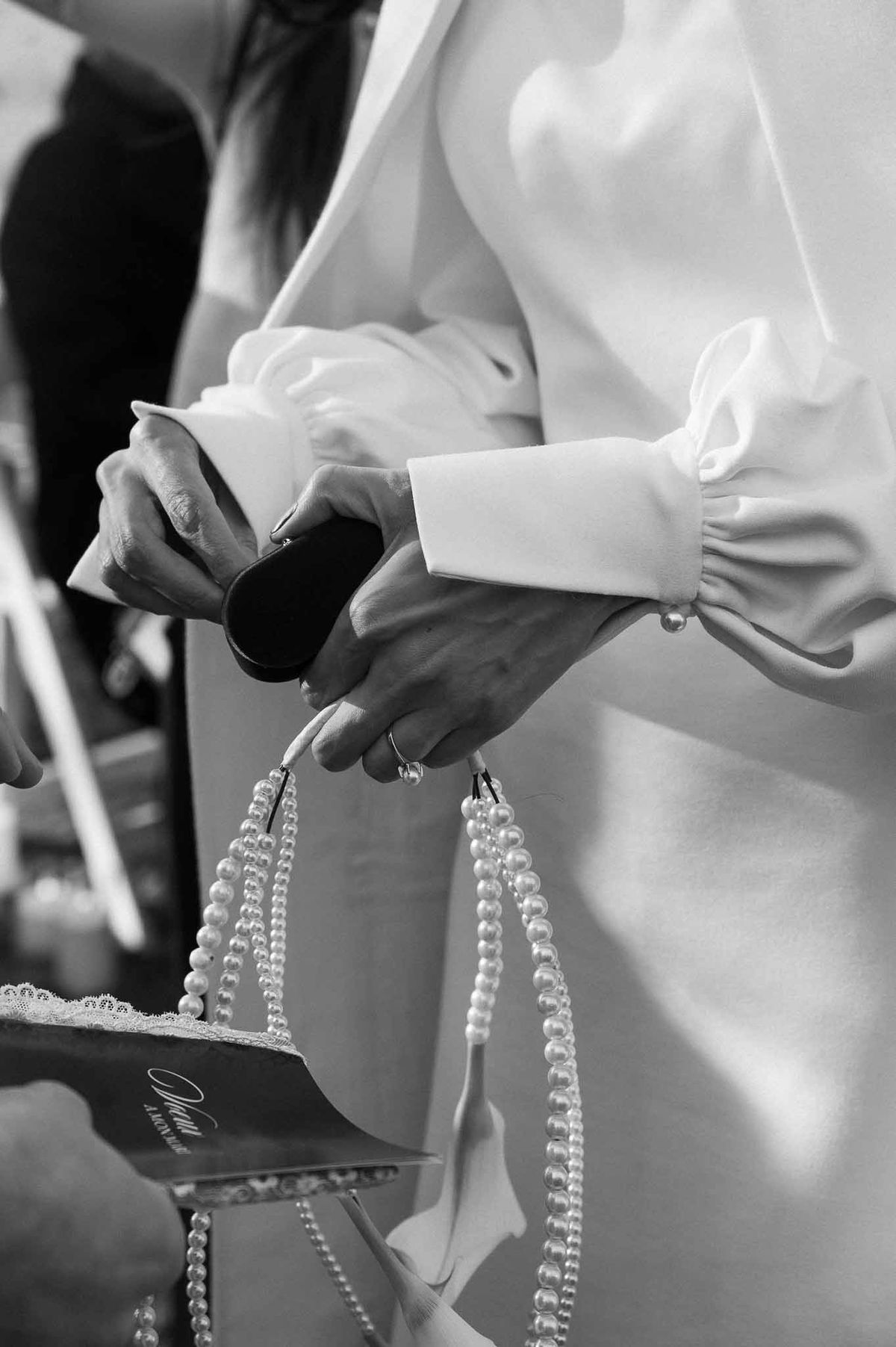 Bride holding pearls and sunglasses at Chateau d'Hazeville