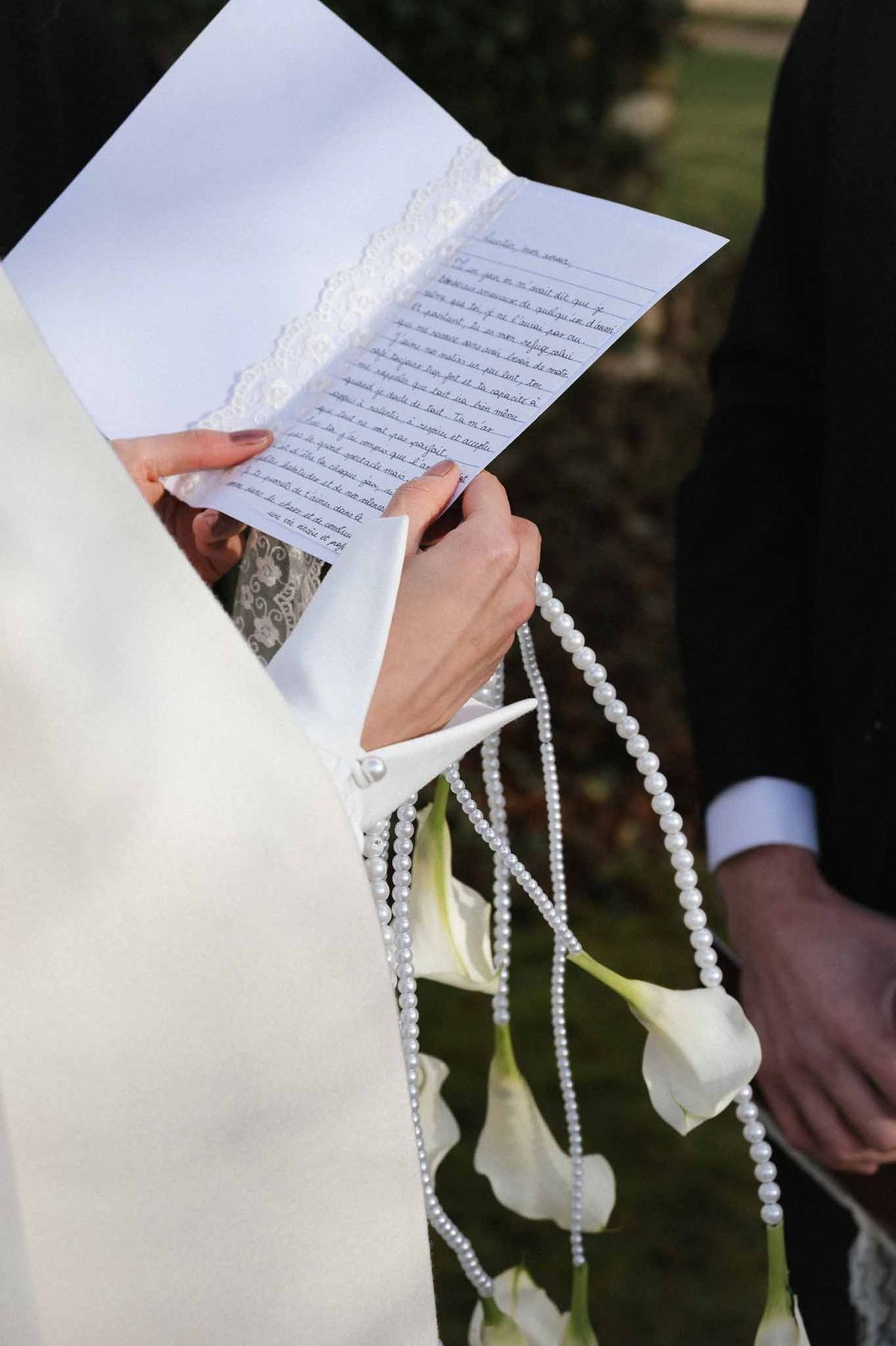 Bride reading vows with calla lily bouquet at Chateau d'Hazeville