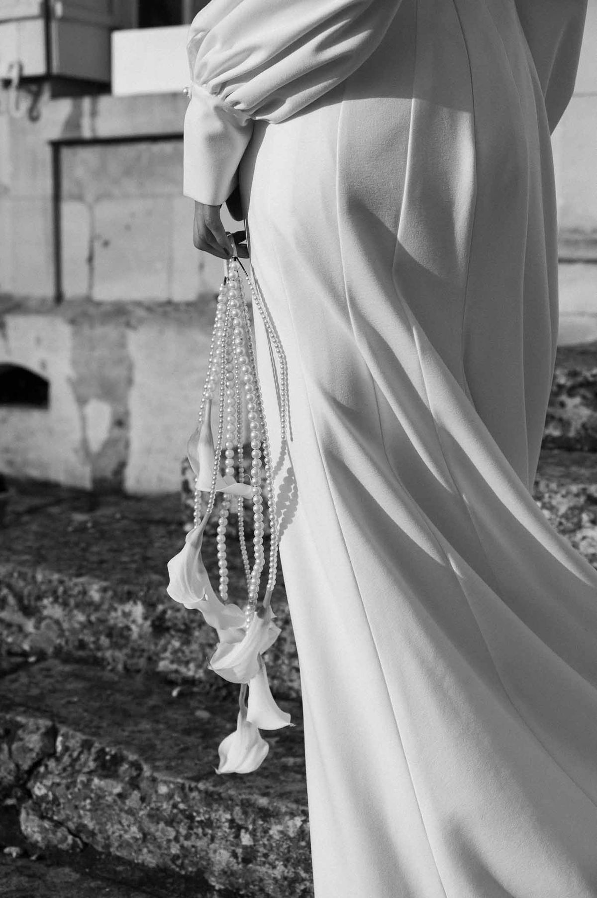 Bride walking on stone steps with pearls at Chateau d'Hazeville