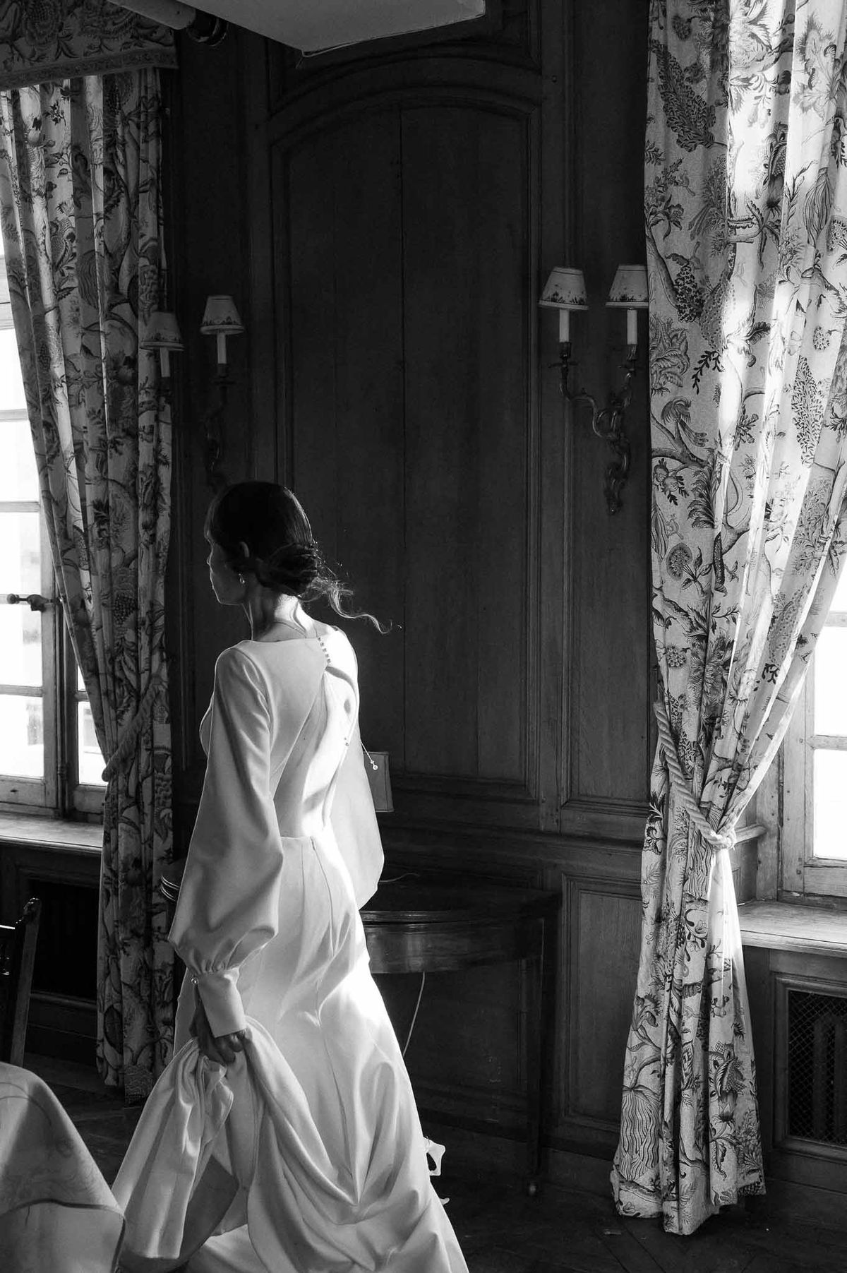 Bride walking through panelled room at Chateau d'Hazeville