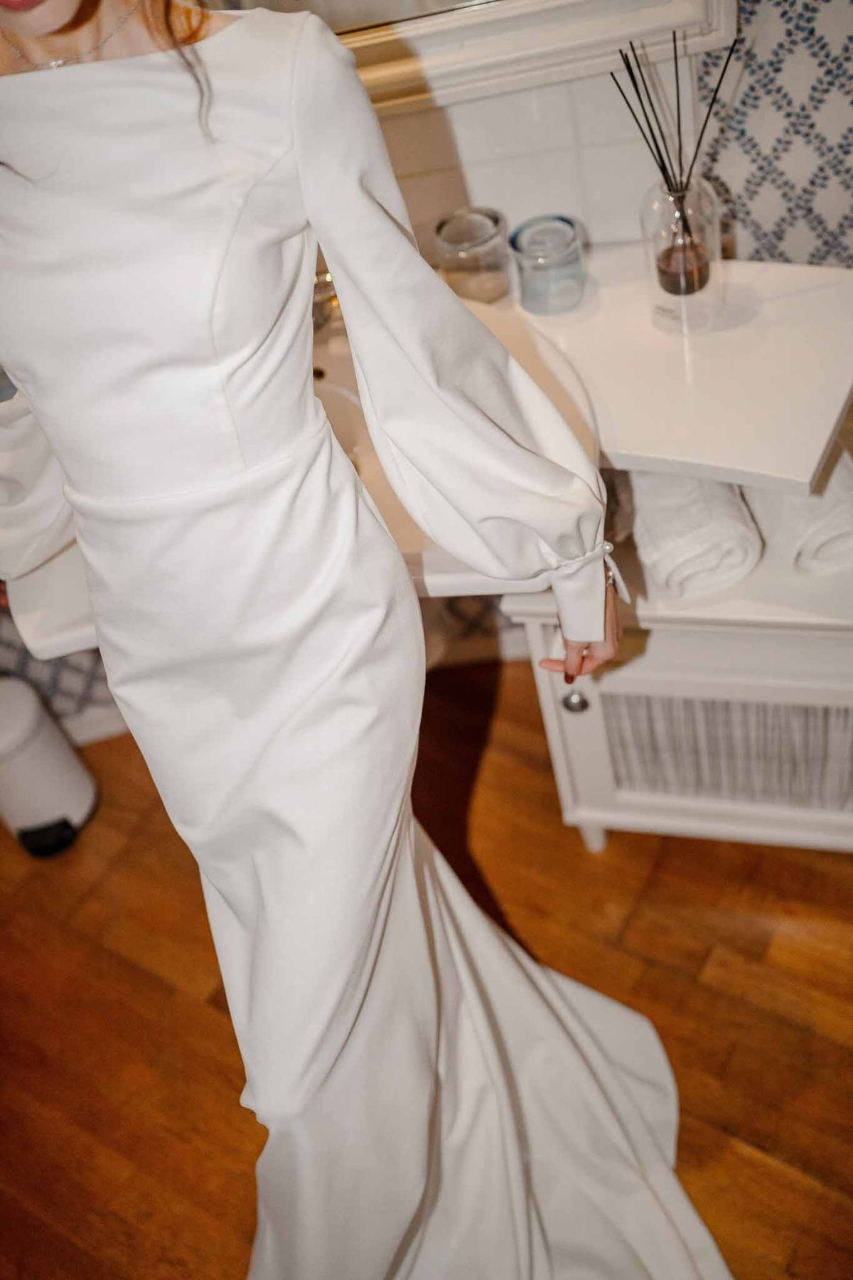 Bride being dressed in satin gown at Chateau d'Hazeville