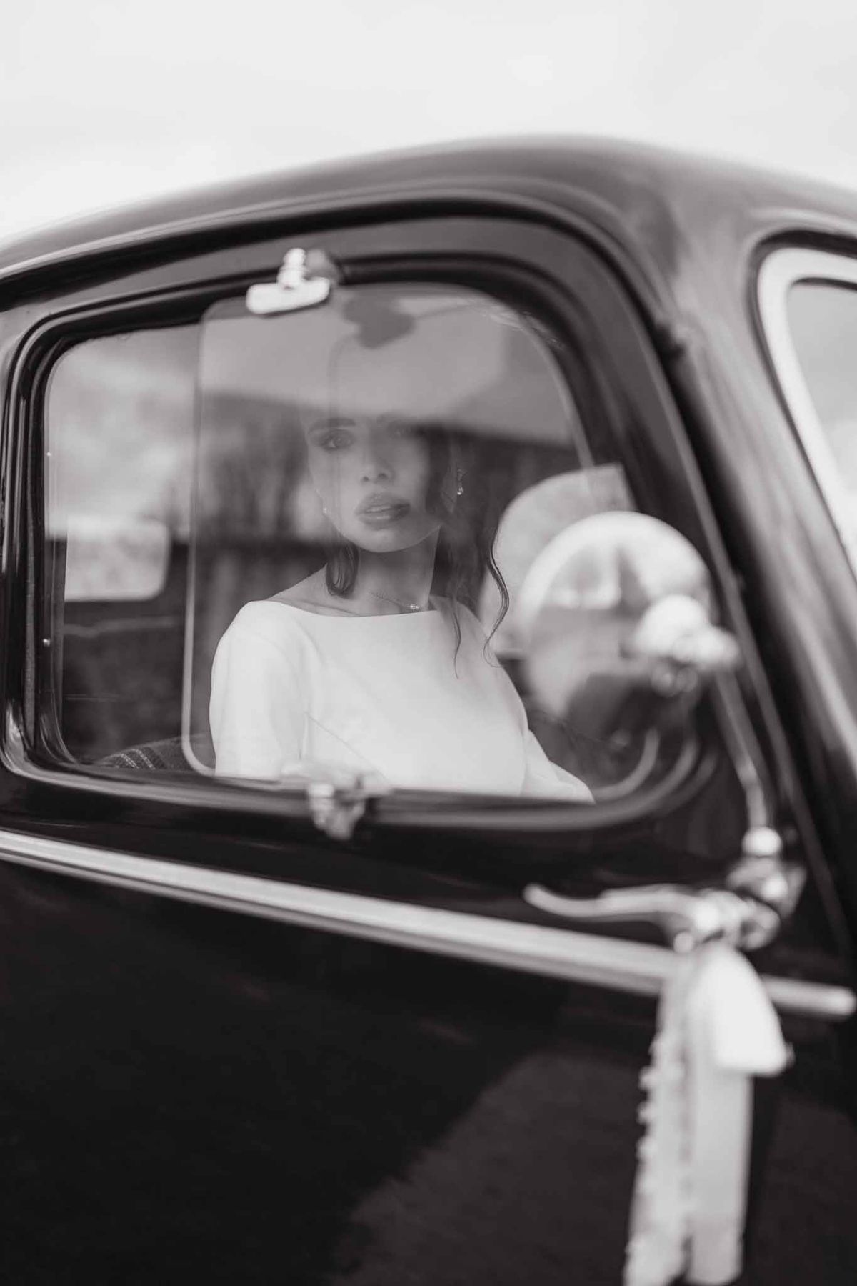 Bride through vintage car window at Chateau d'Hazeville