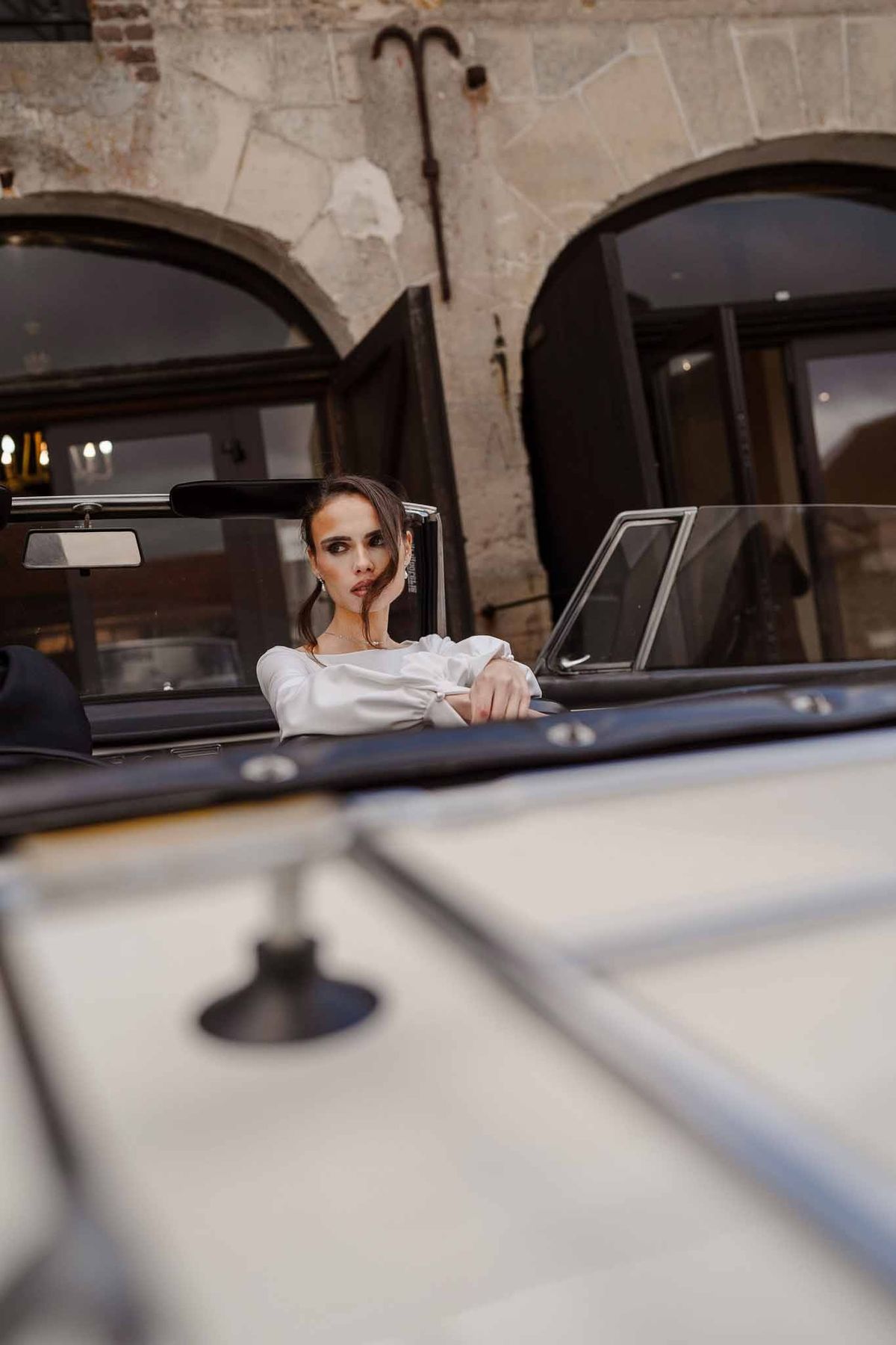 Bride in vintage convertible at Chateau d'Hazeville