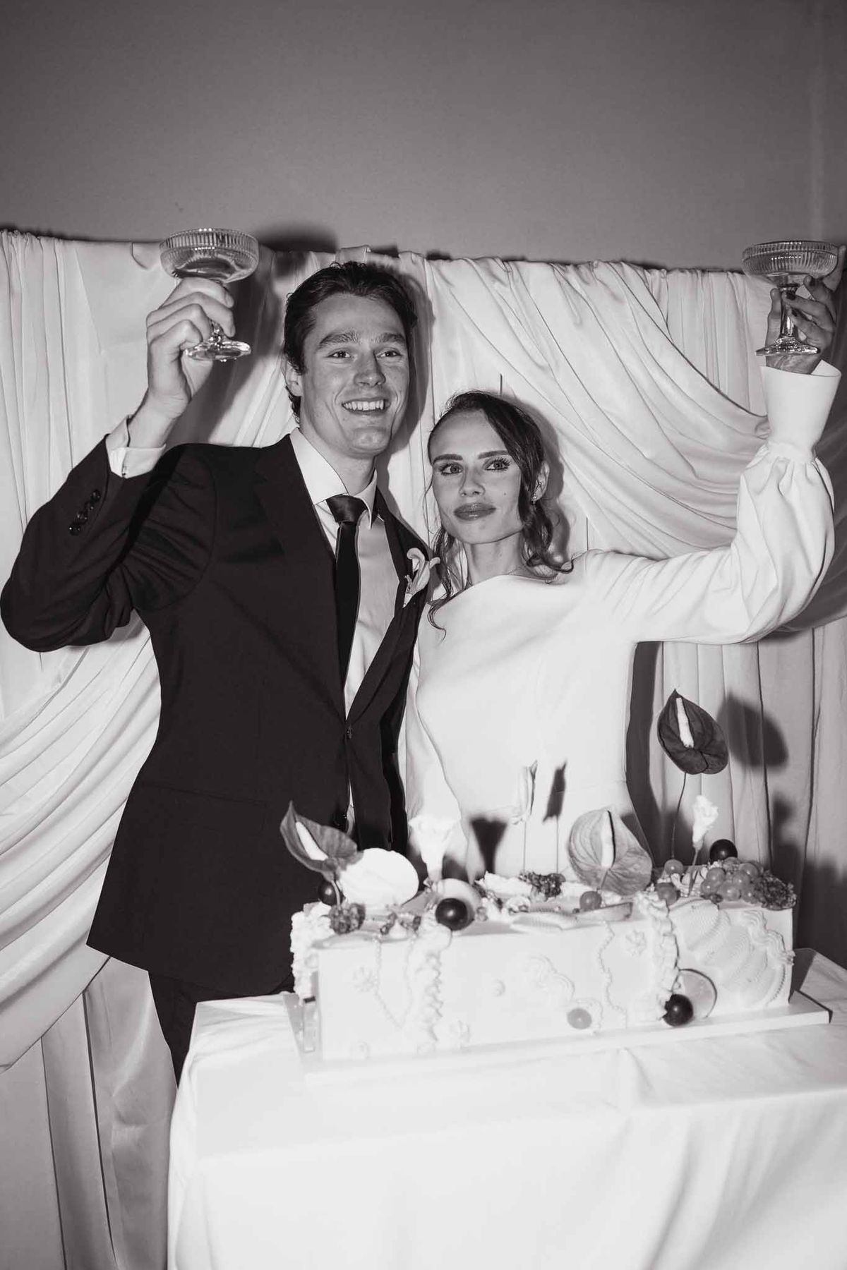 Couple toasting over wedding cake at Chateau d'Hazeville