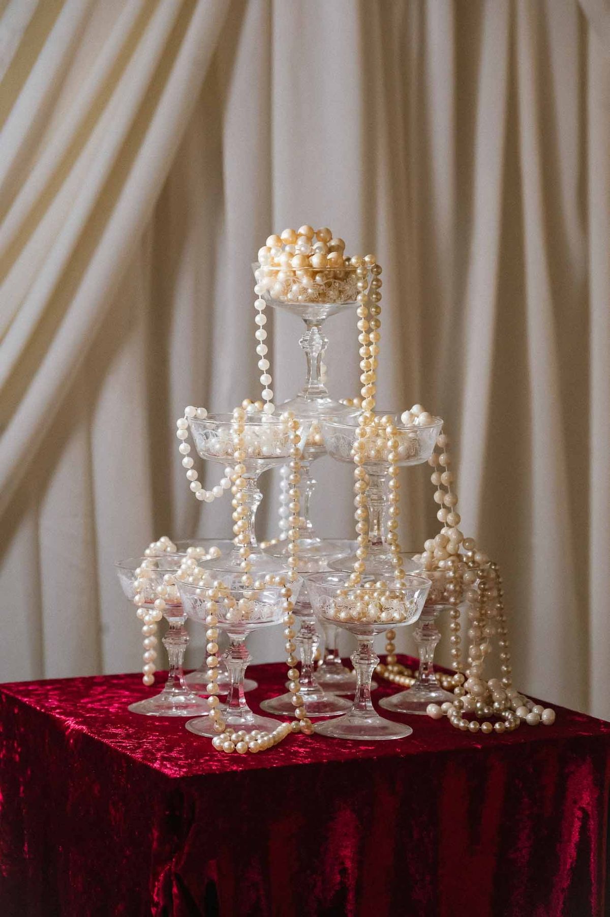 Pearl-draped champagne tower on burgundy velvet at Chateau d'Hazeville