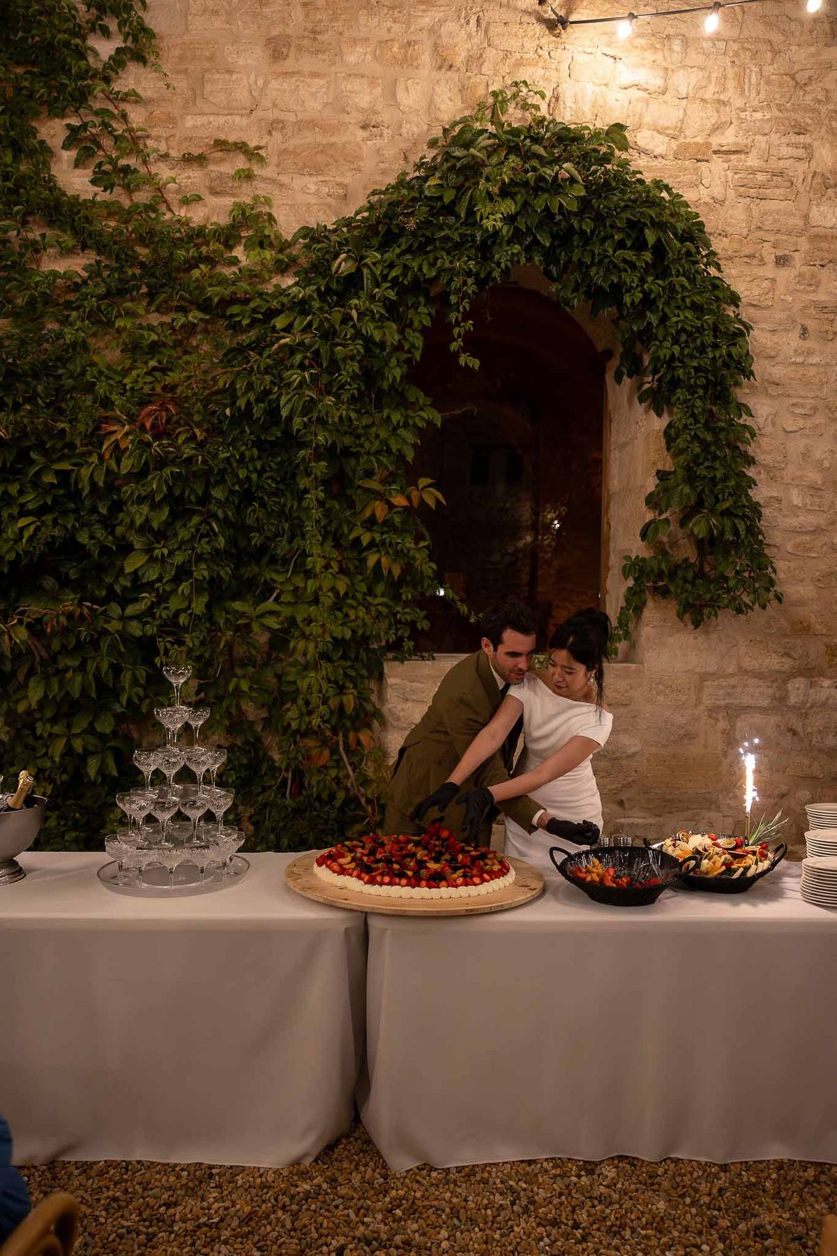 Bride and groom together with wedding cake and champagne glasses at the reception table