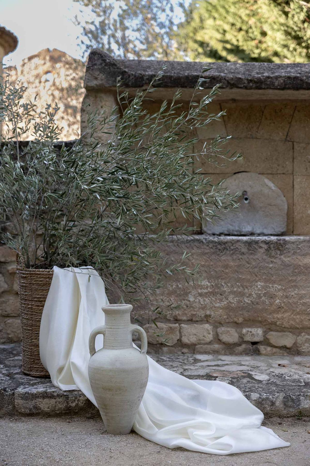 Vintage vase with simple green floral arrangement against stone brick wall