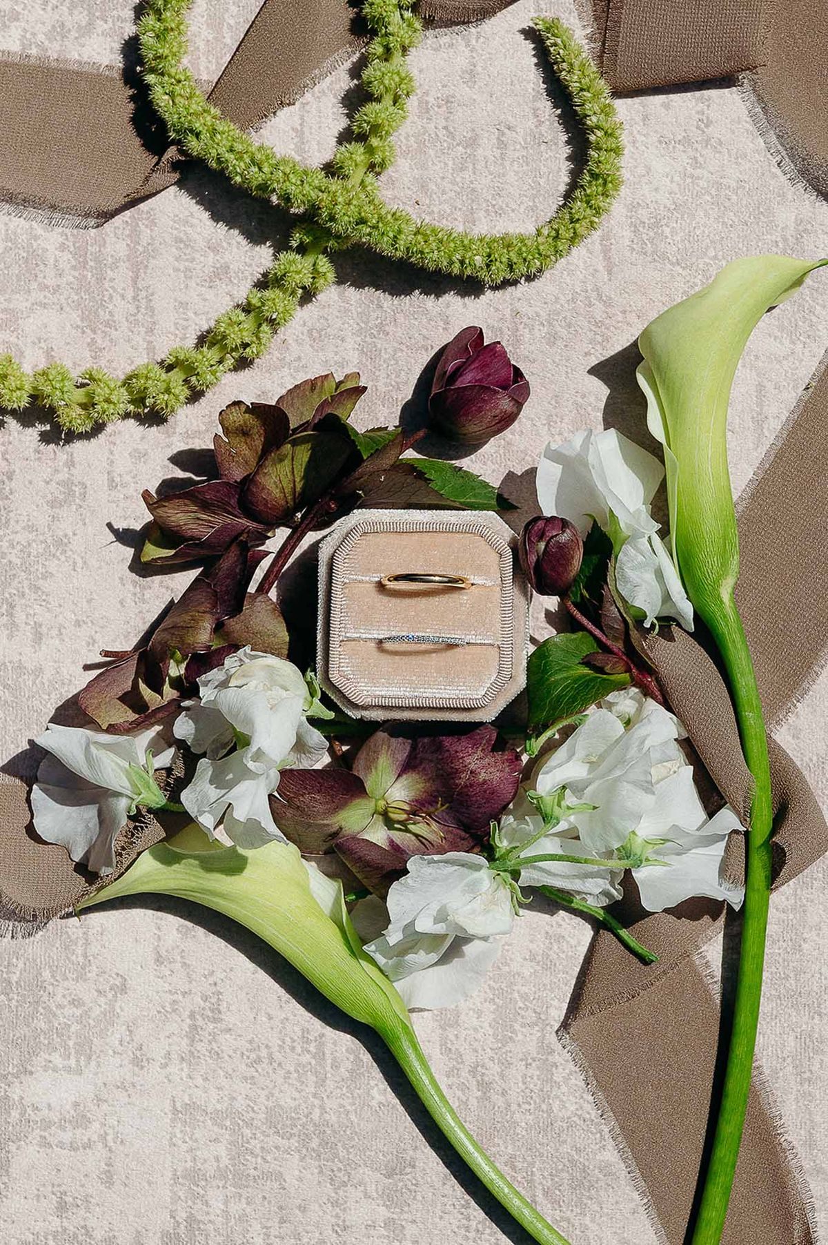 Flat lay of wedding accessories including diamond ring and flowers at Domaine de Perrotin