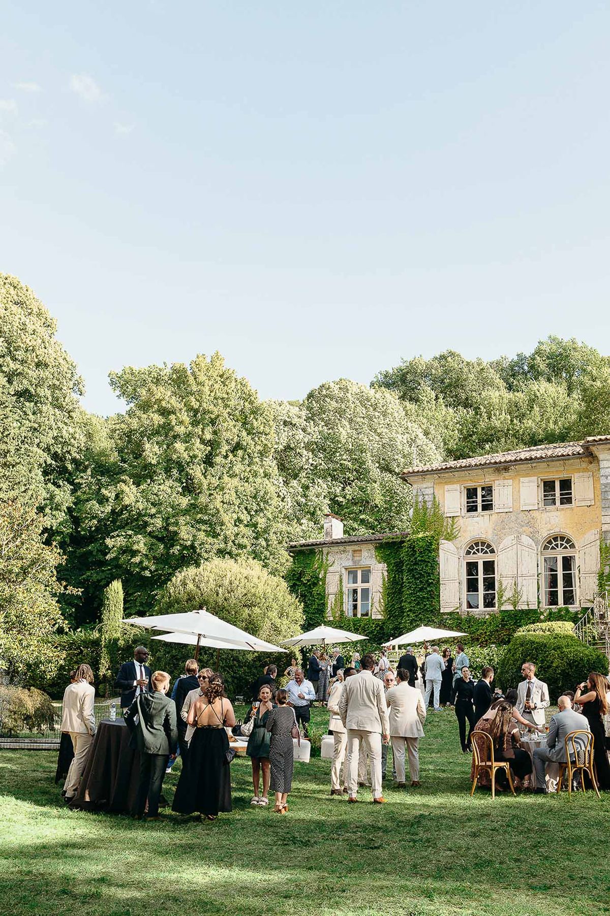 Guests socialising in the garden cocktail area at Domaine de Perrotin