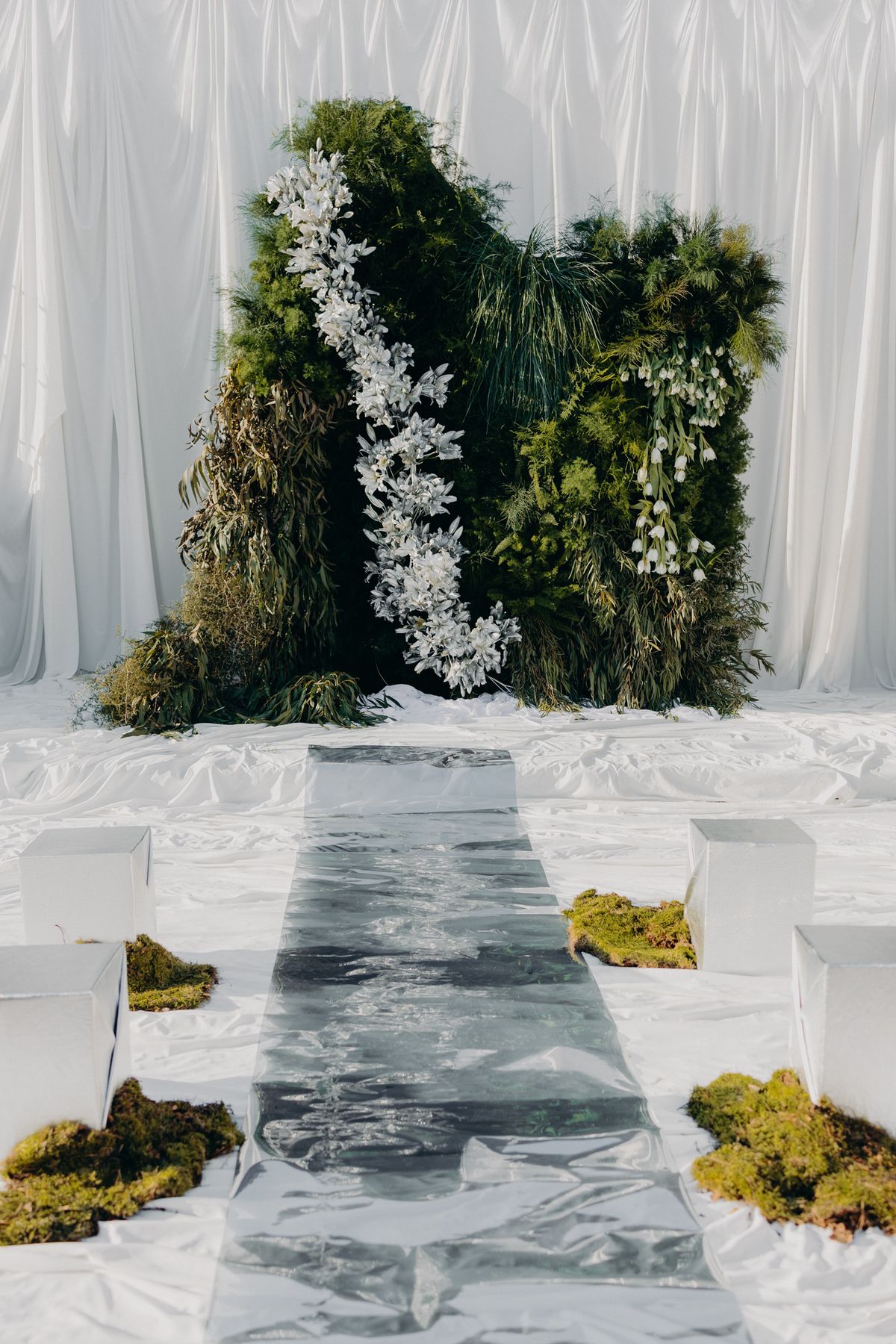 Mirrored aisle runway leading to the white floral altar installation