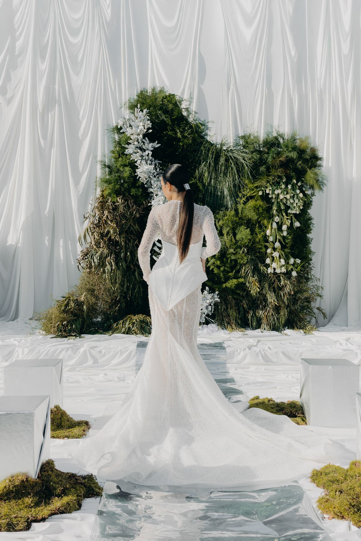 Bride from behind on the mirrored aisle facing the altar