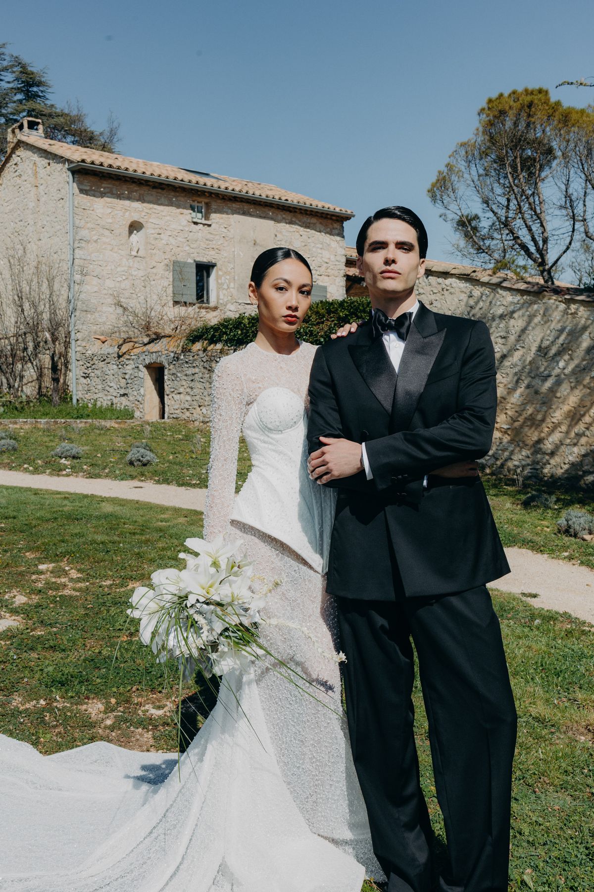 Bride and groom together on the lawn with a white bouquet