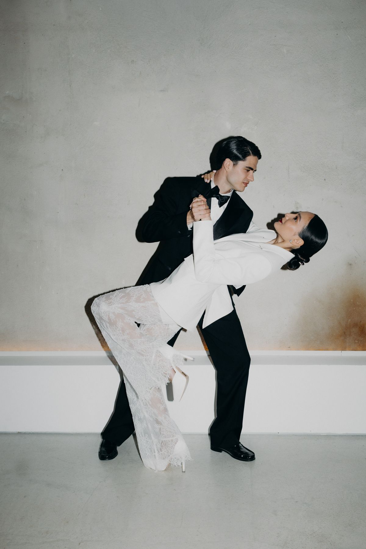 Bride and groom dancing, the bride in a white suit