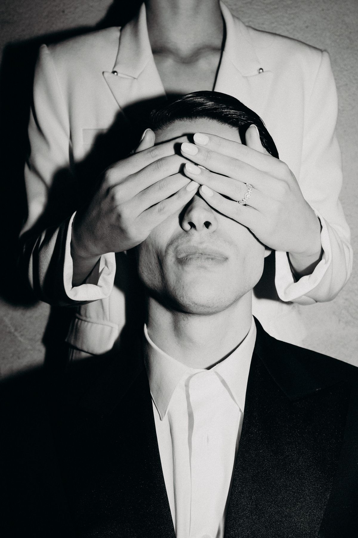Bride covering the groom's eyes, black and white