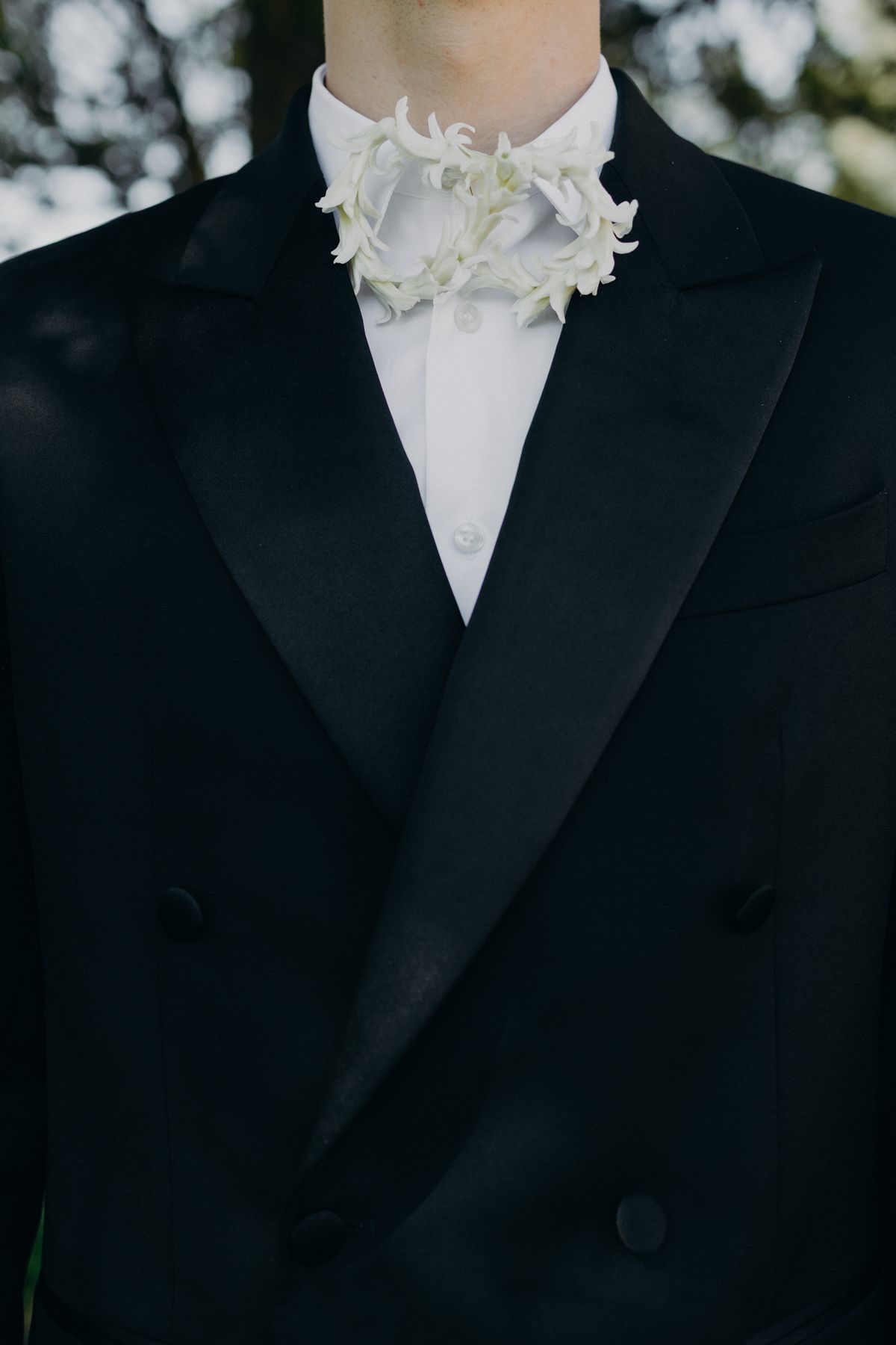 Close detail of the tuxedo lapel and beaded bow tie