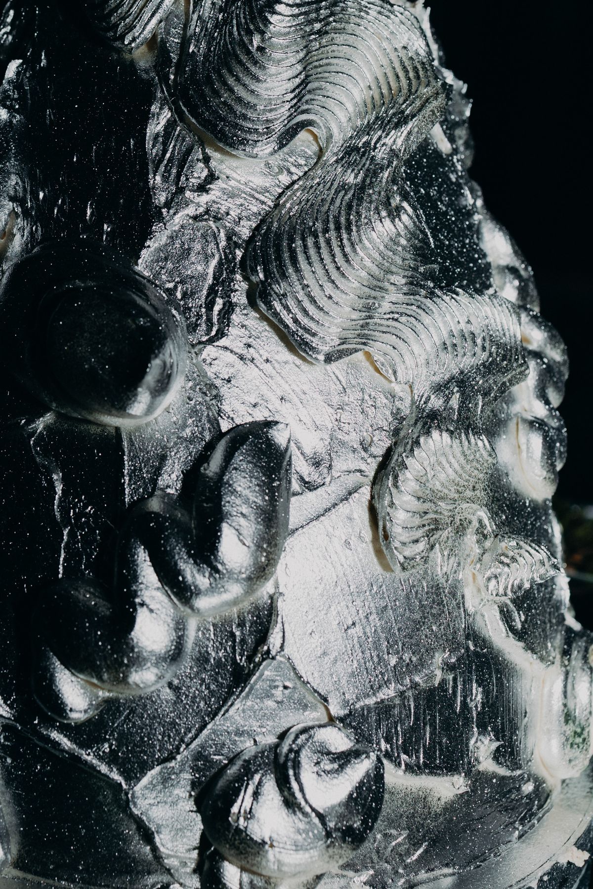 Close detail of the sculptural silver cake