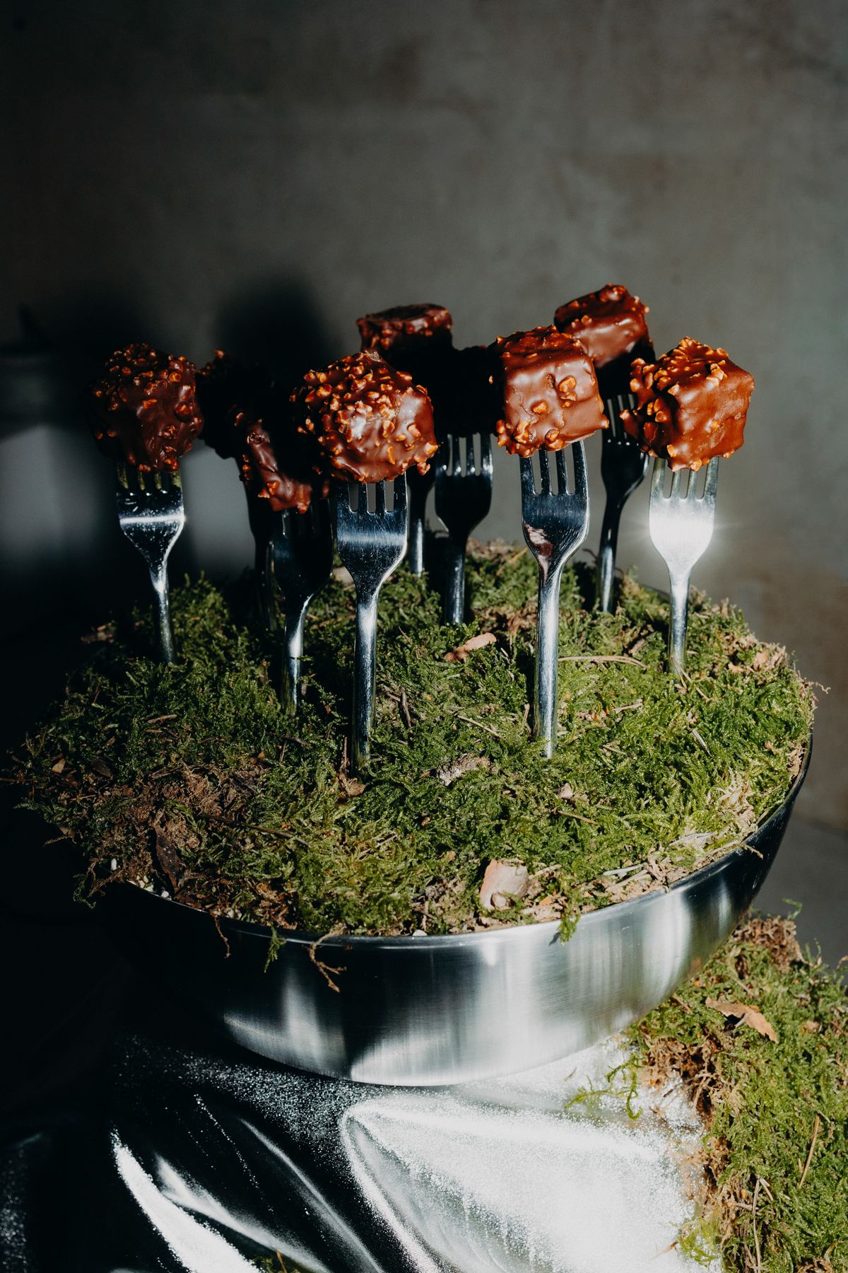 Dessert forks with red flowers set in moss