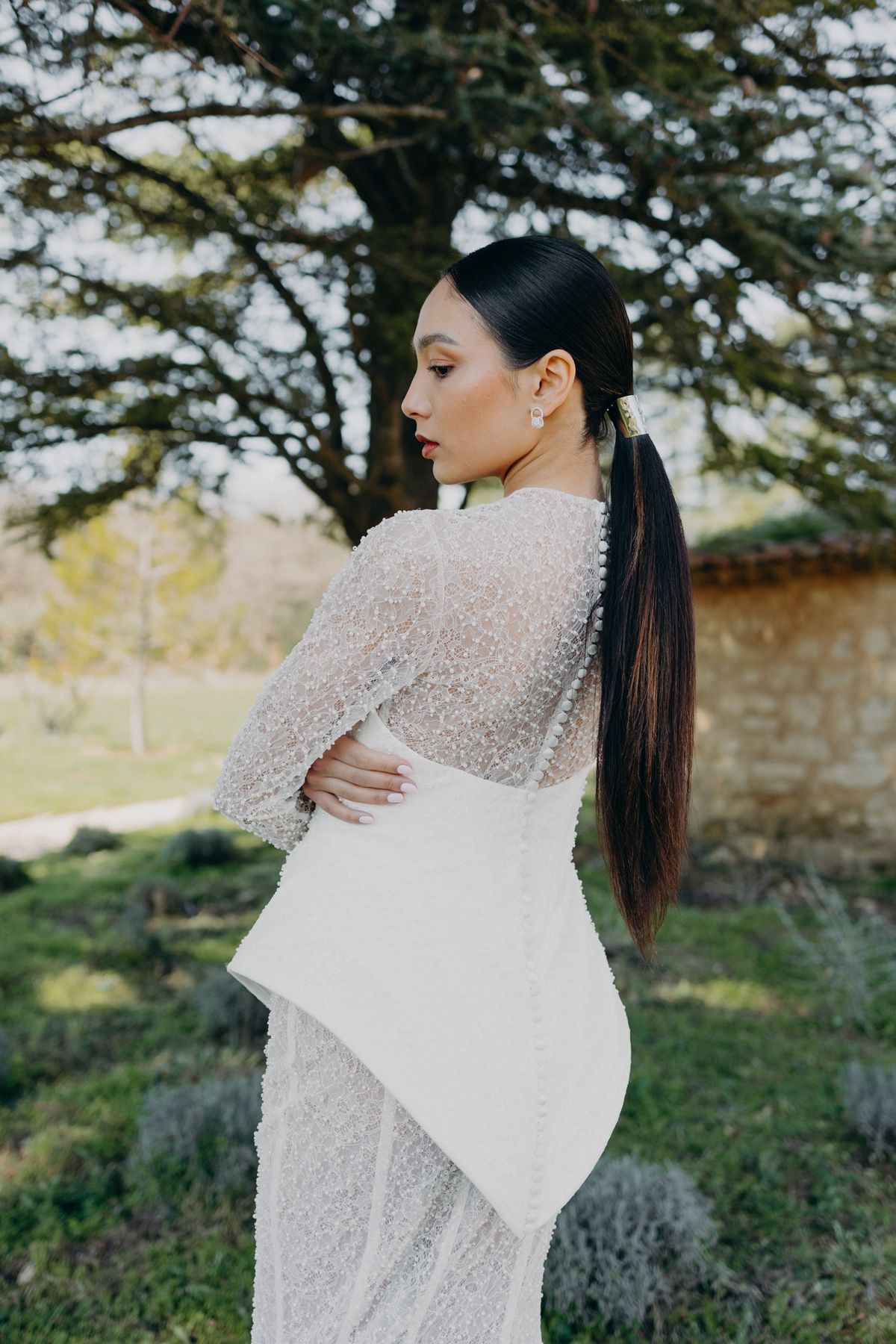 Bride in a beaded high-neck gown beneath a cedar tree