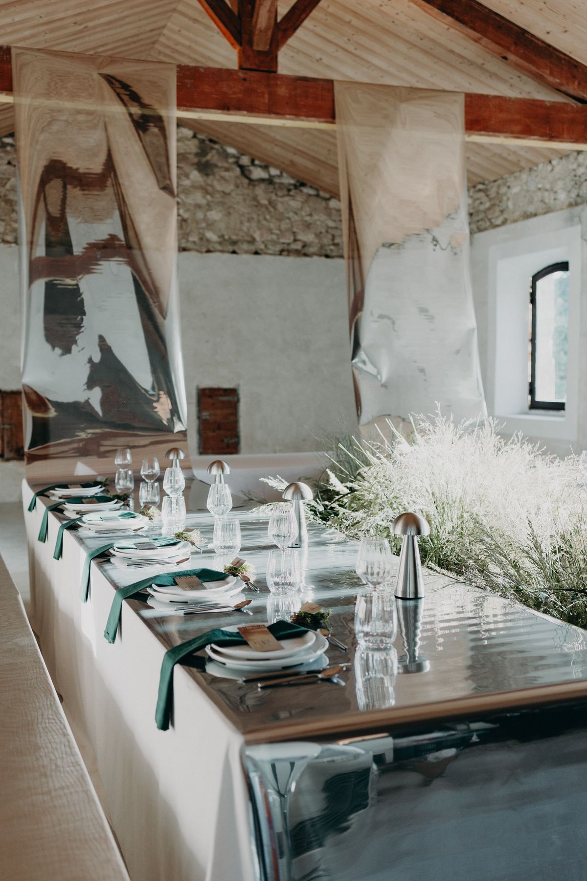 The former barn set for dinner beneath exposed beams
