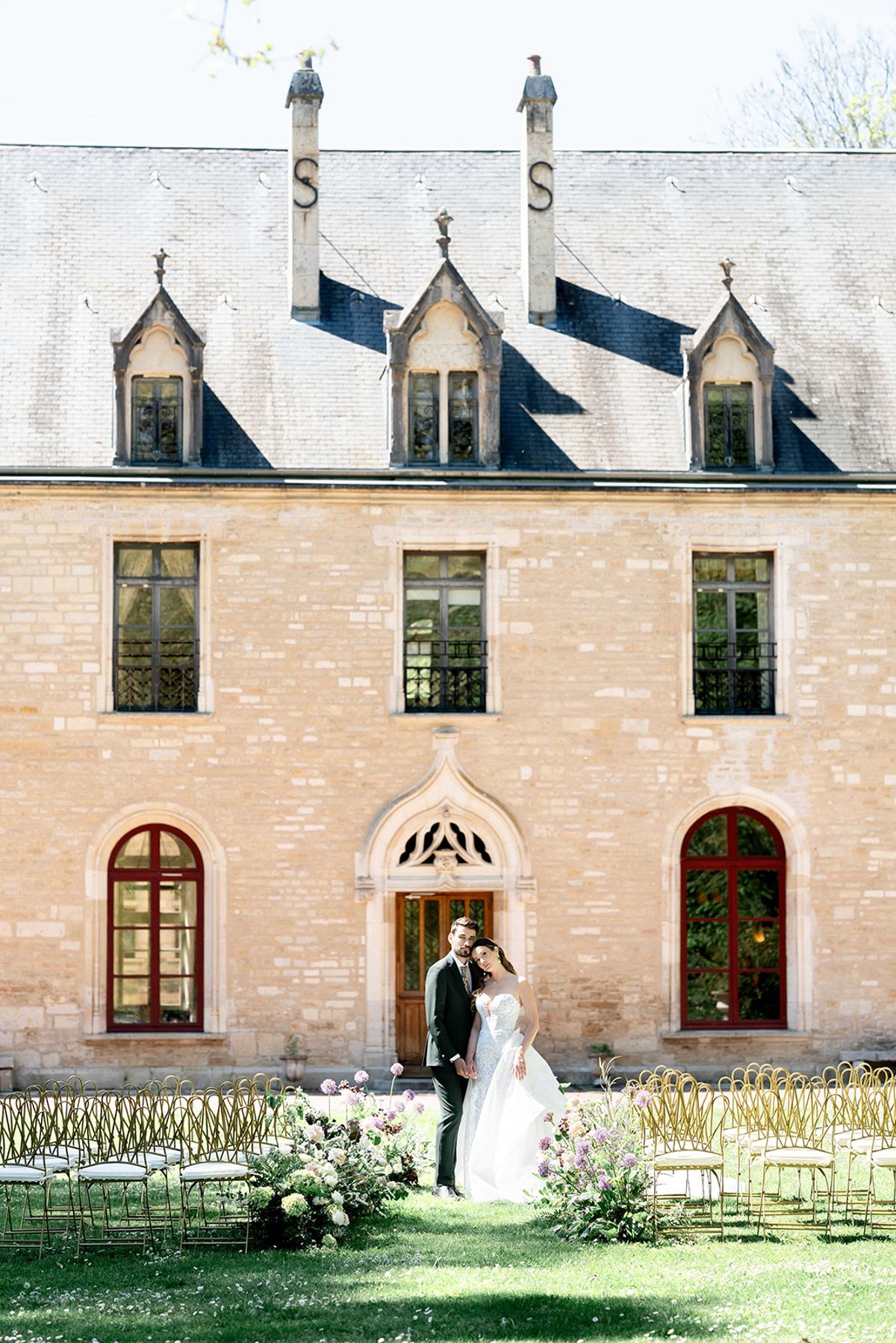 The couple standing together in front of the abbey at the ceremony
