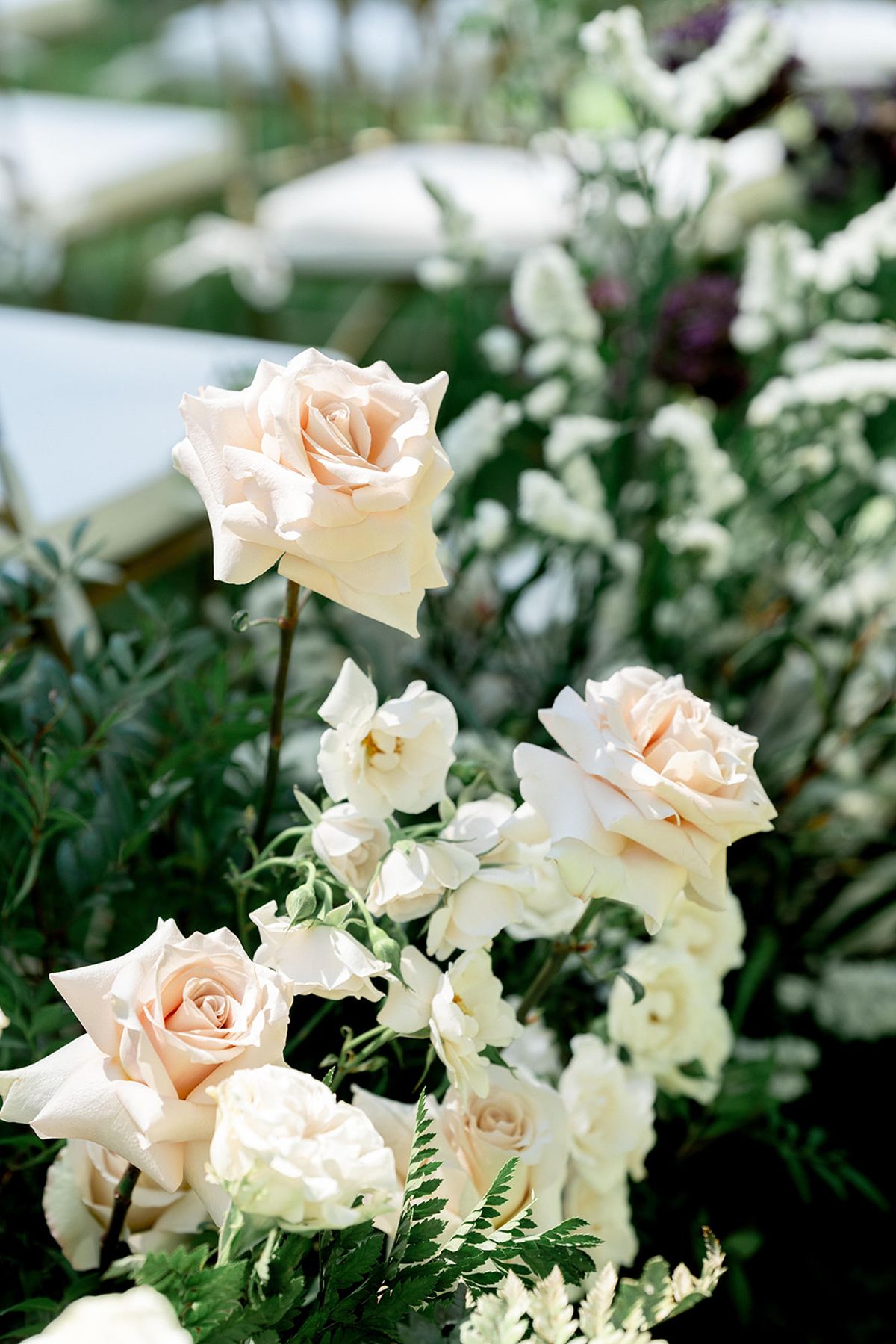 Close view of the ceremony florals in white roses and greenery