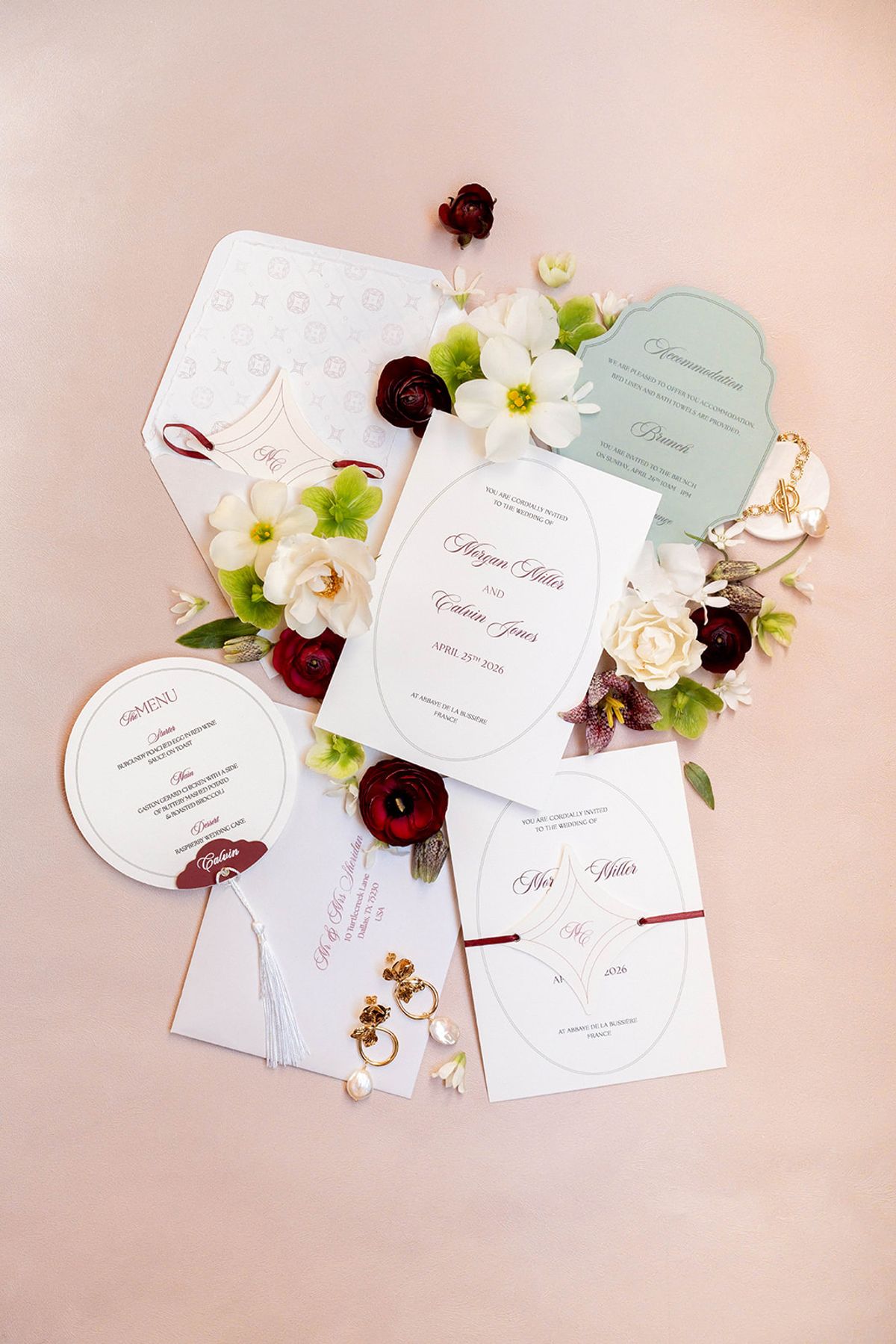 Wedding stationery suite laid out with menus and burgundy and cream flowers