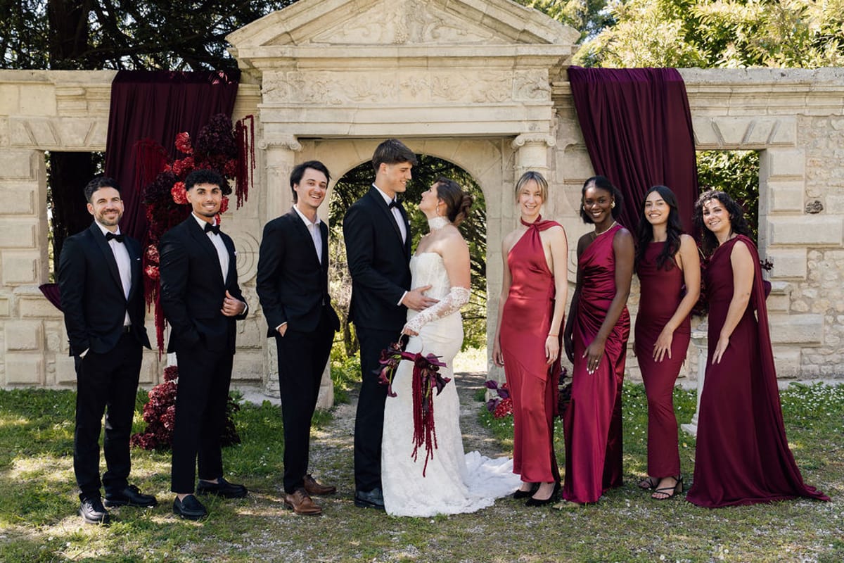 Styled shoot models Harper and Liam: the wedding party gathered at the archway, Chateau de Mirambeau, spring editorial