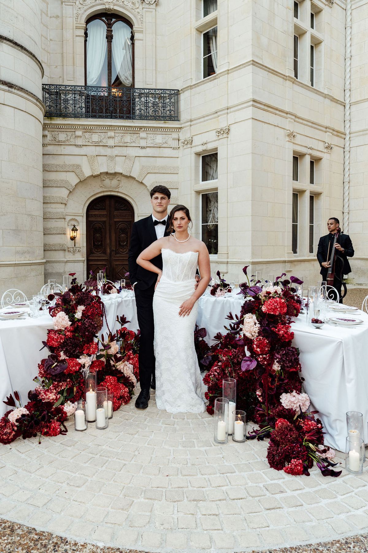 Styled shoot models Harper and Liam: the couple standing together beside the reception table, Chateau de Mirambeau, spring editorial