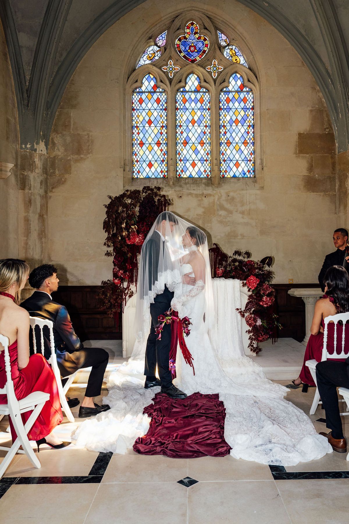 Styled shoot models Harper and Liam: the ceremony scene beneath the chapel's stained glass, Chateau de Mirambeau, spring editorial