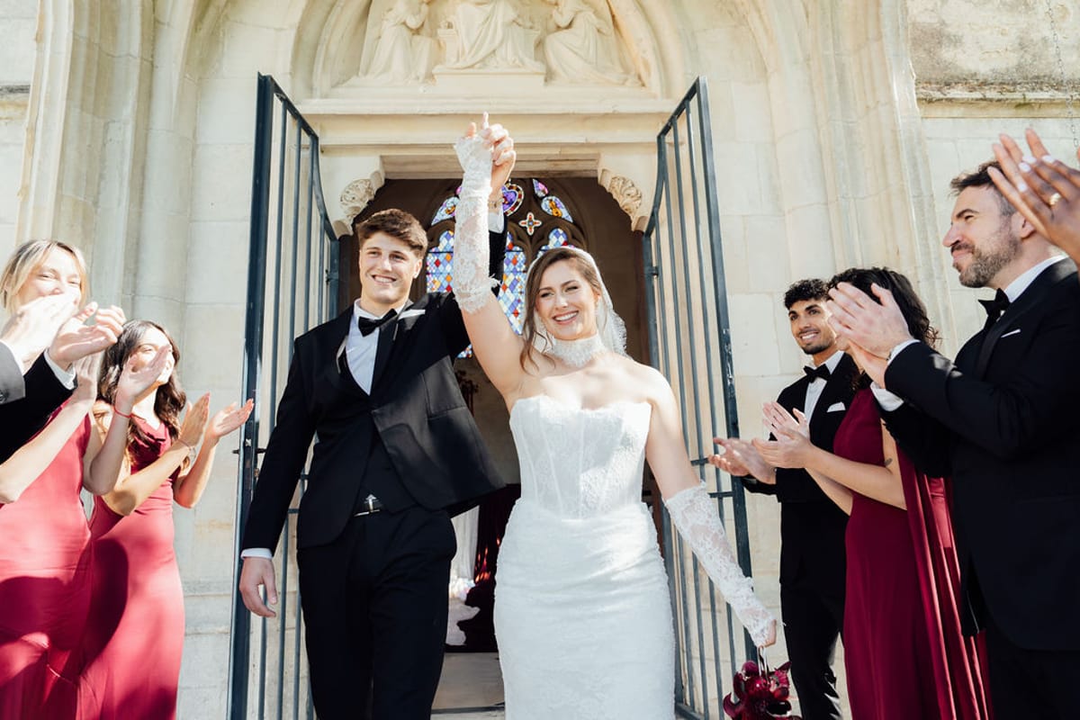 Styled shoot models Harper and Liam: the couple walking out to applause after the ceremony, Chateau de Mirambeau, spring editorial