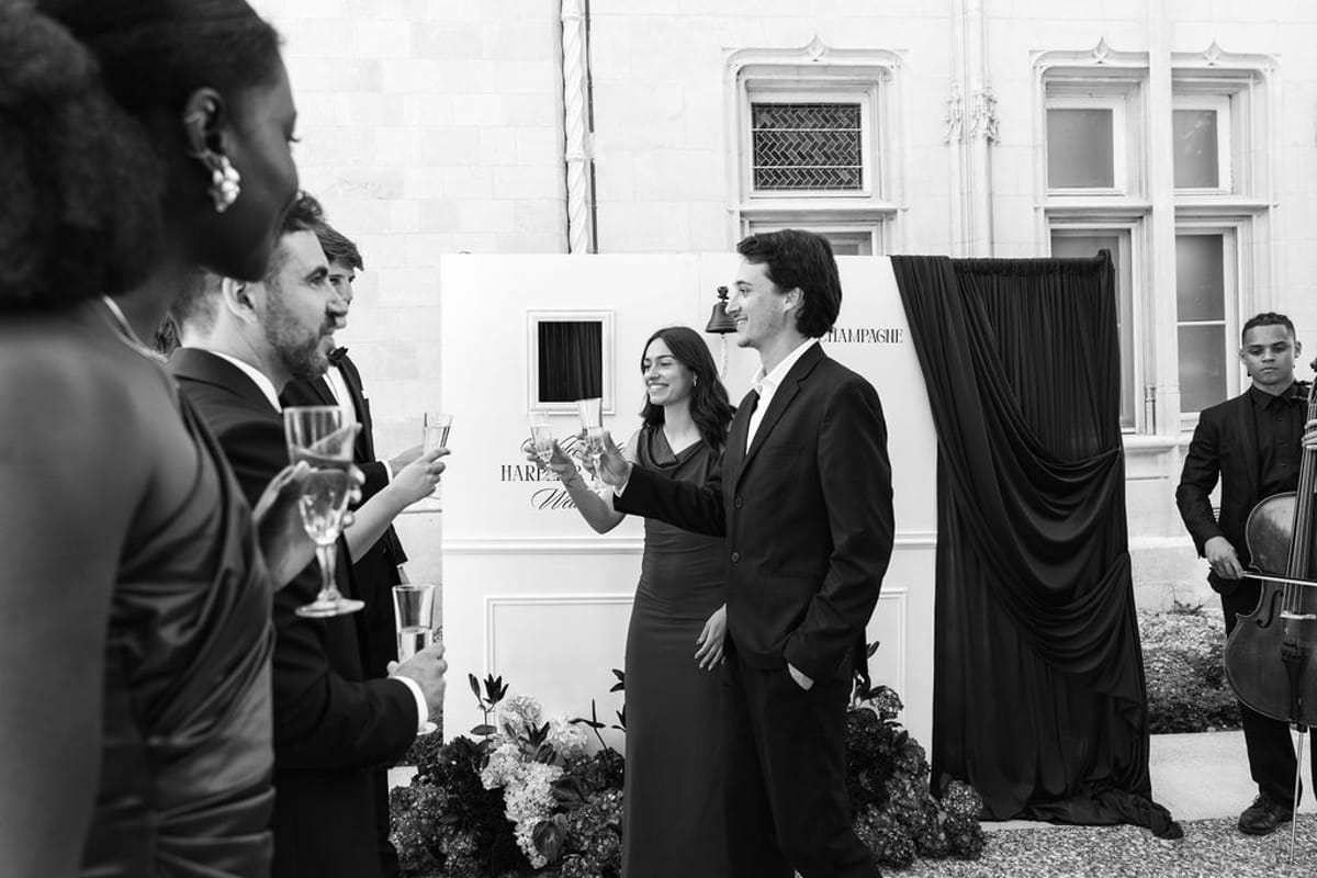 Styled shoot models Harper and Liam: the couple toasting outdoors as the cellist plays on, Chateau de Mirambeau, spring editorial