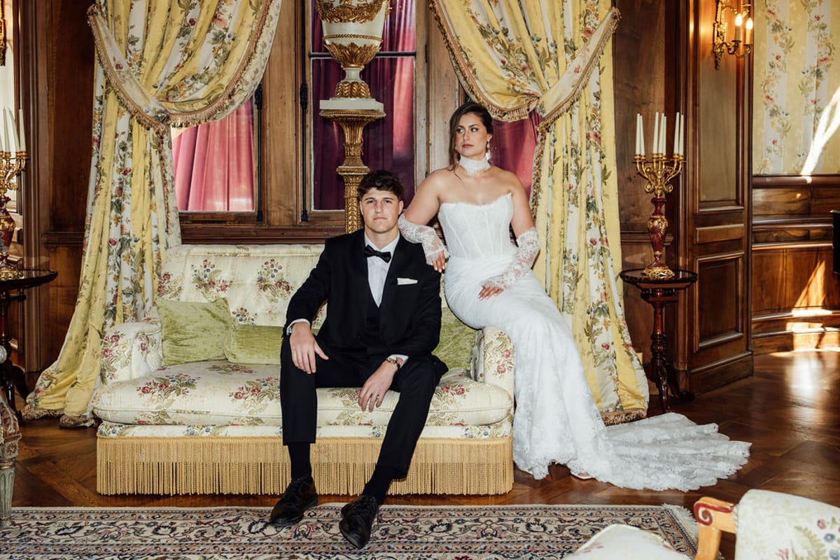 Styled shoot models Harper and Liam: the couple seated together on an antique settee, Chateau de Mirambeau, spring editorial