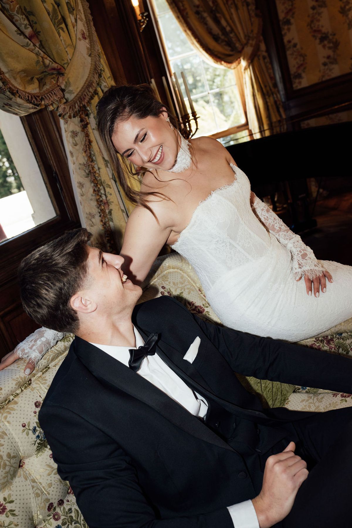 Styled shoot models Harper and Liam: the couple close in laughter inside the chateau's gilded rooms, Chateau de Mirambeau, spring editorial
