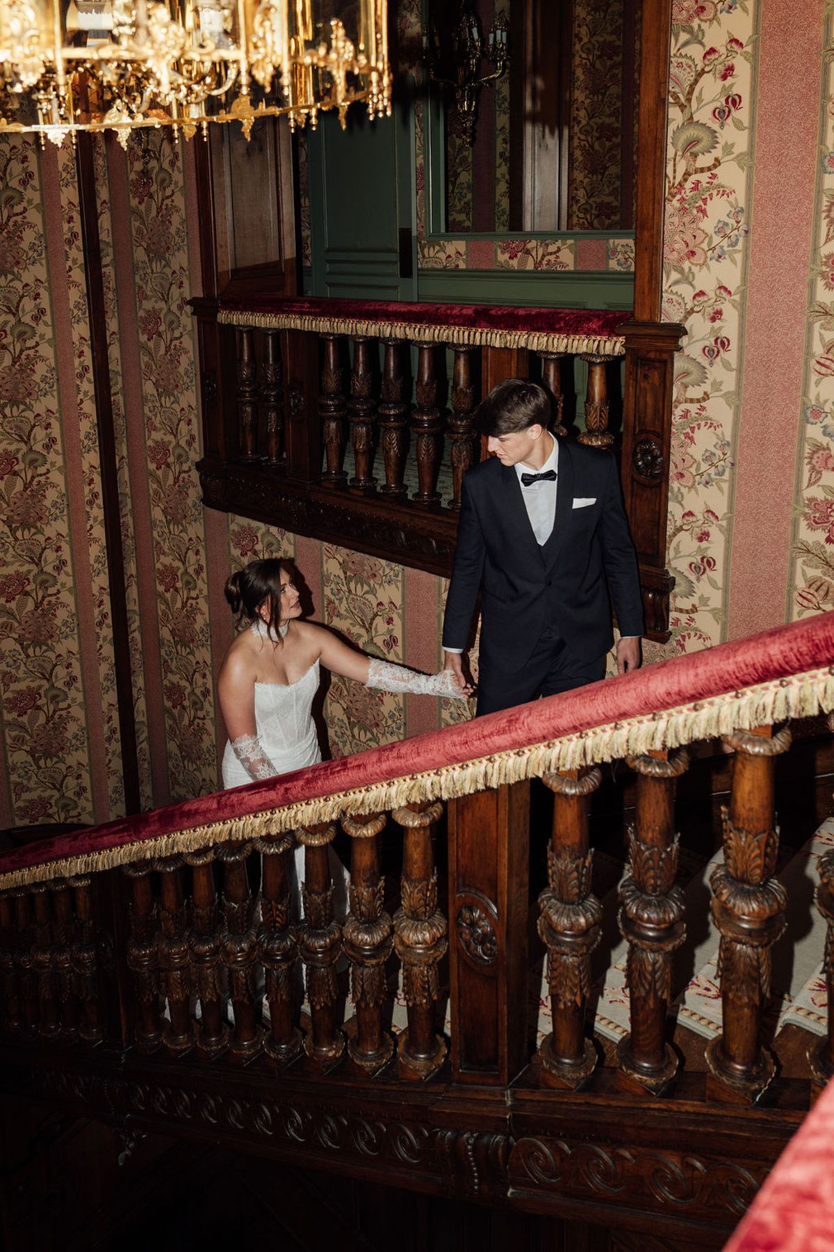Styled shoot models Harper and Liam: the couple pausing on a grand staircase, Chateau de Mirambeau, spring editorial