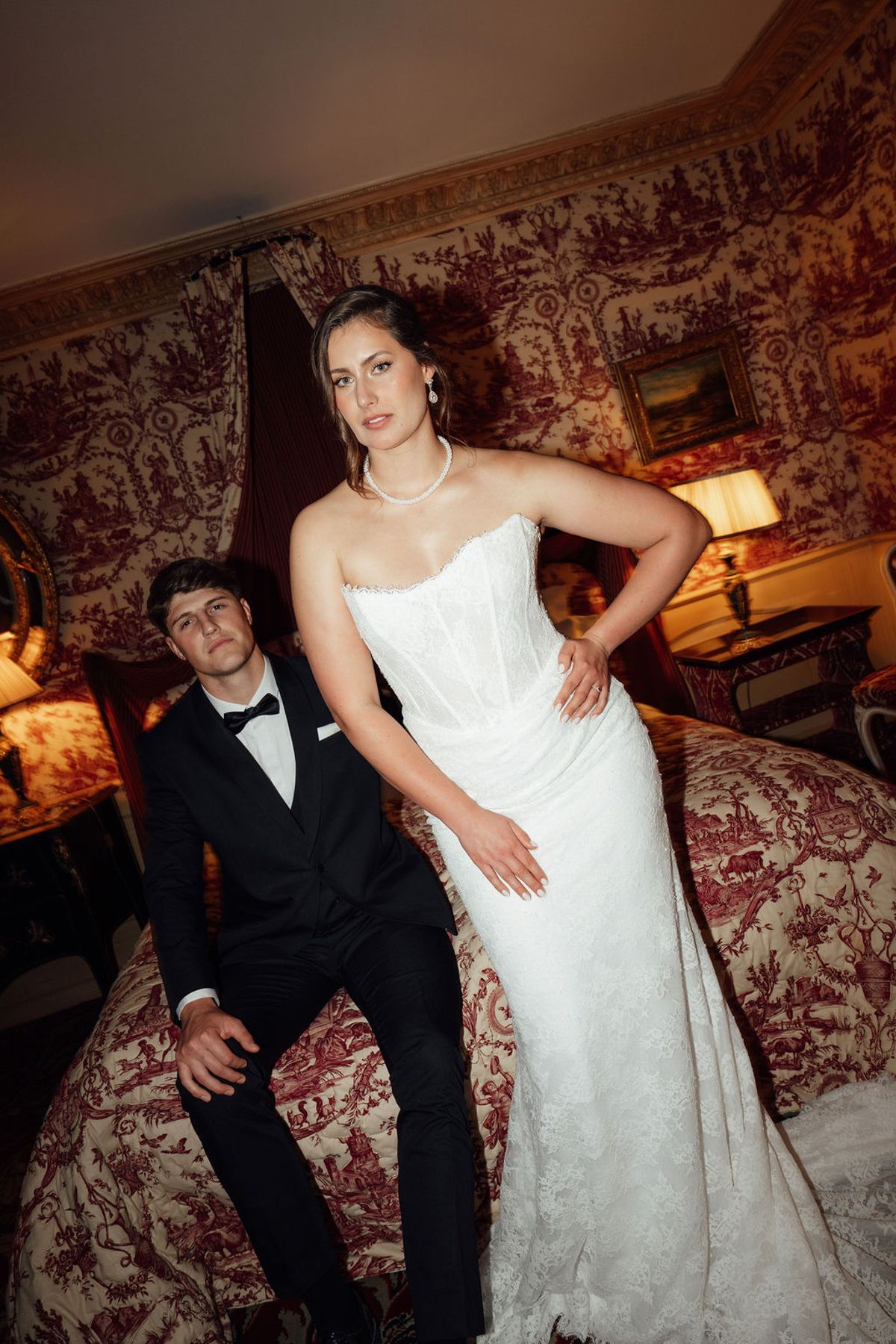 Styled shoot models Harper and Liam: the couple seated together in a firelit interior, Chateau de Mirambeau, spring editorial