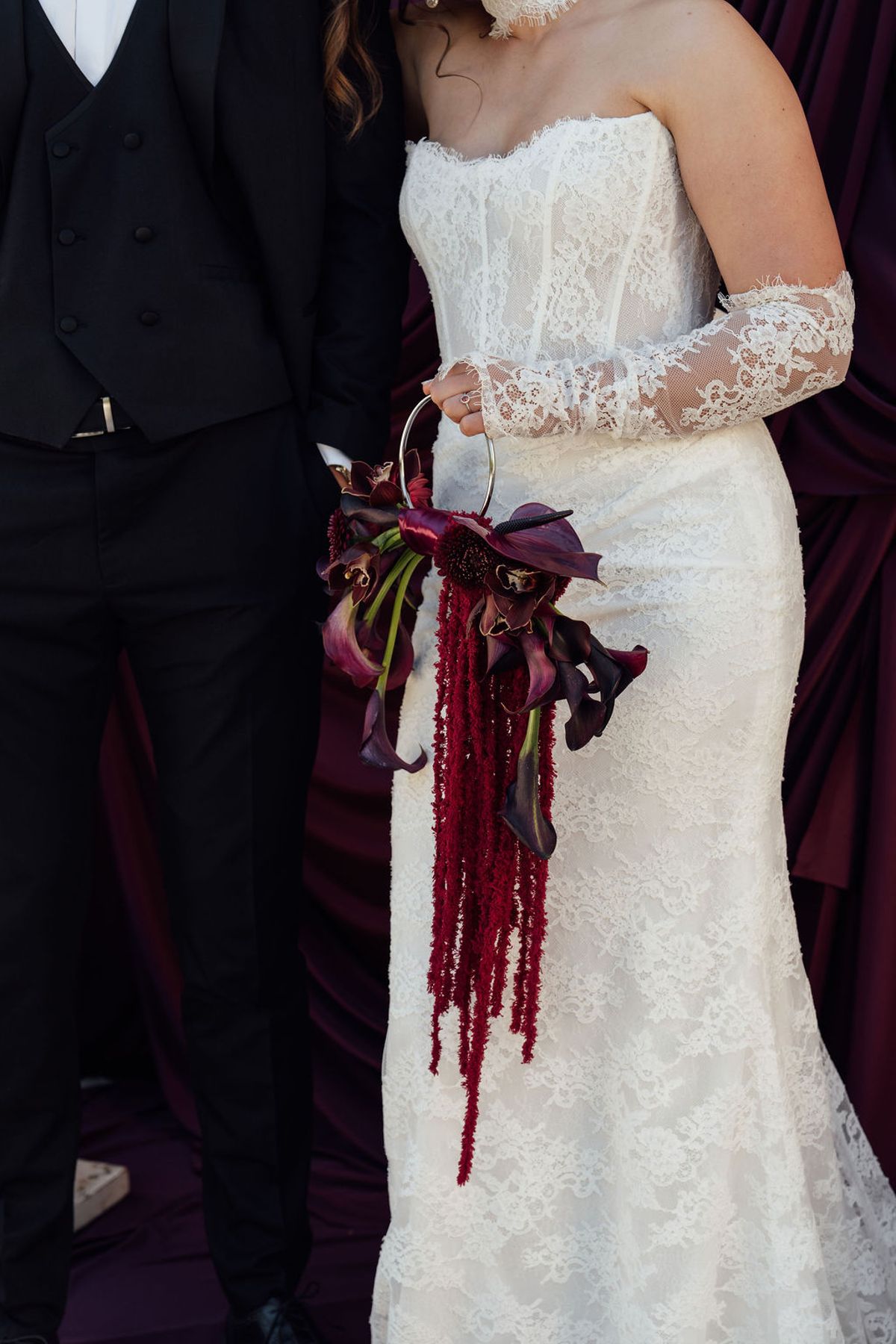 Styled shoot models Harper and Liam: the trailing burgundy bouquet against the lace gown, Chateau de Mirambeau, spring editorial